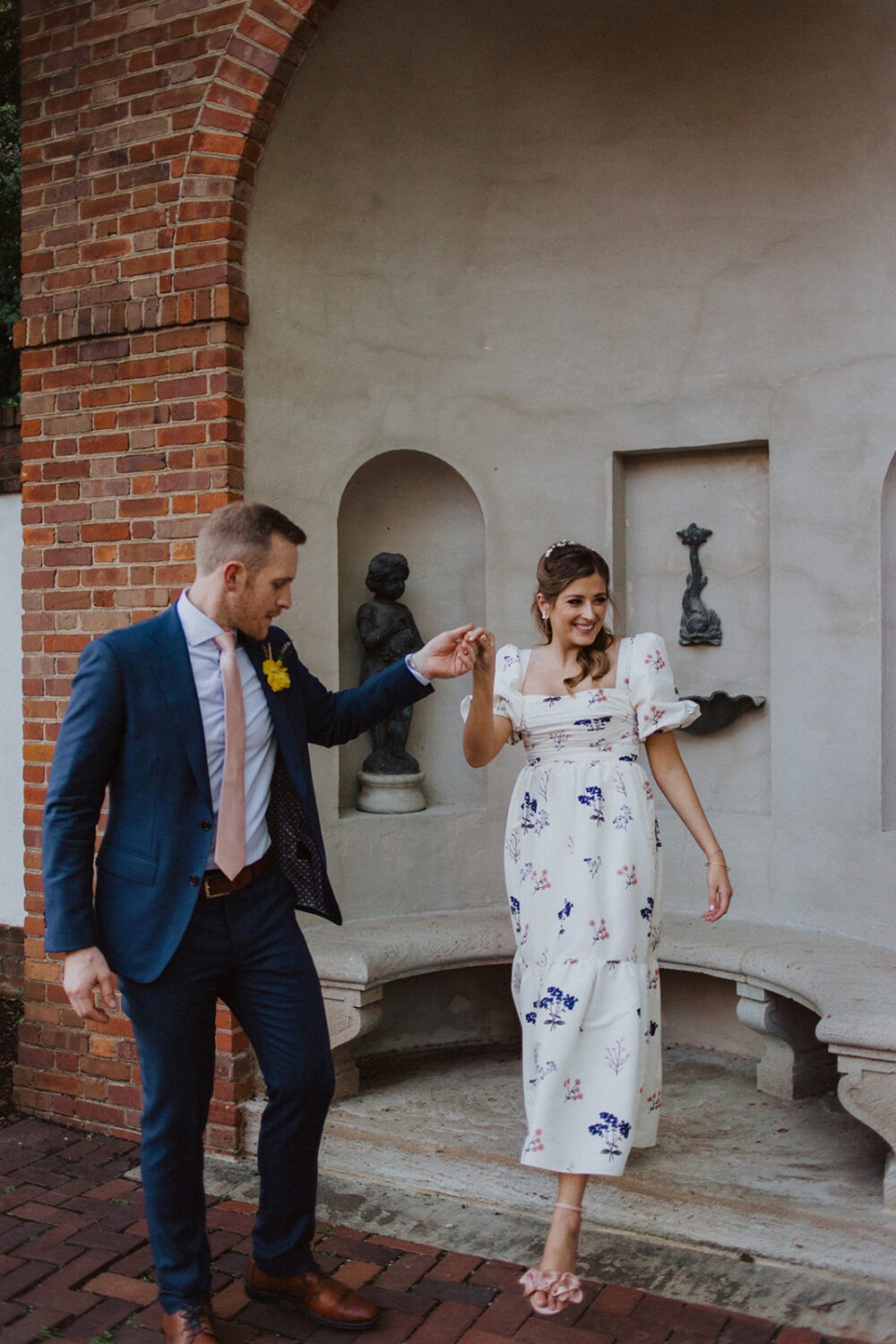 couple walks holding hands at Dumbarton House garden wedding