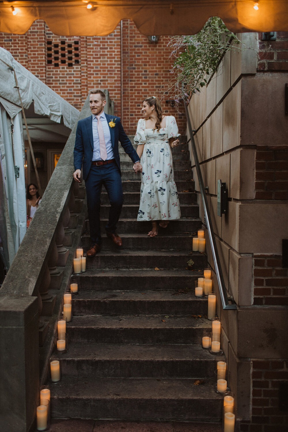 couple walks down candlelit staircase at wedding