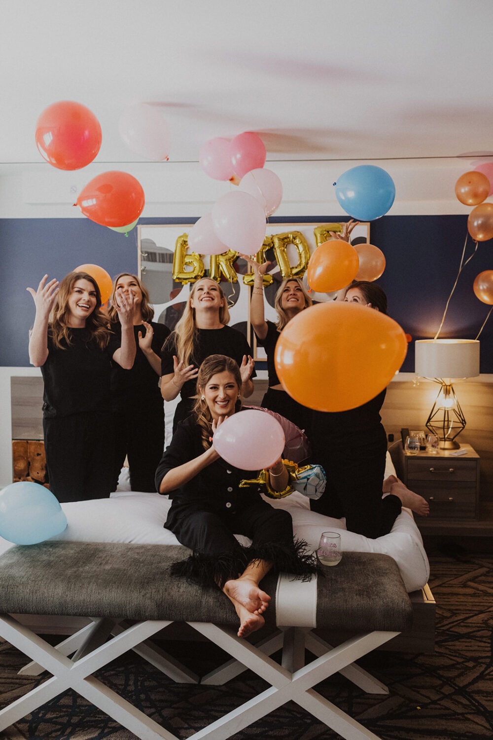 bride throws balloons with bridesmaids on wedding day