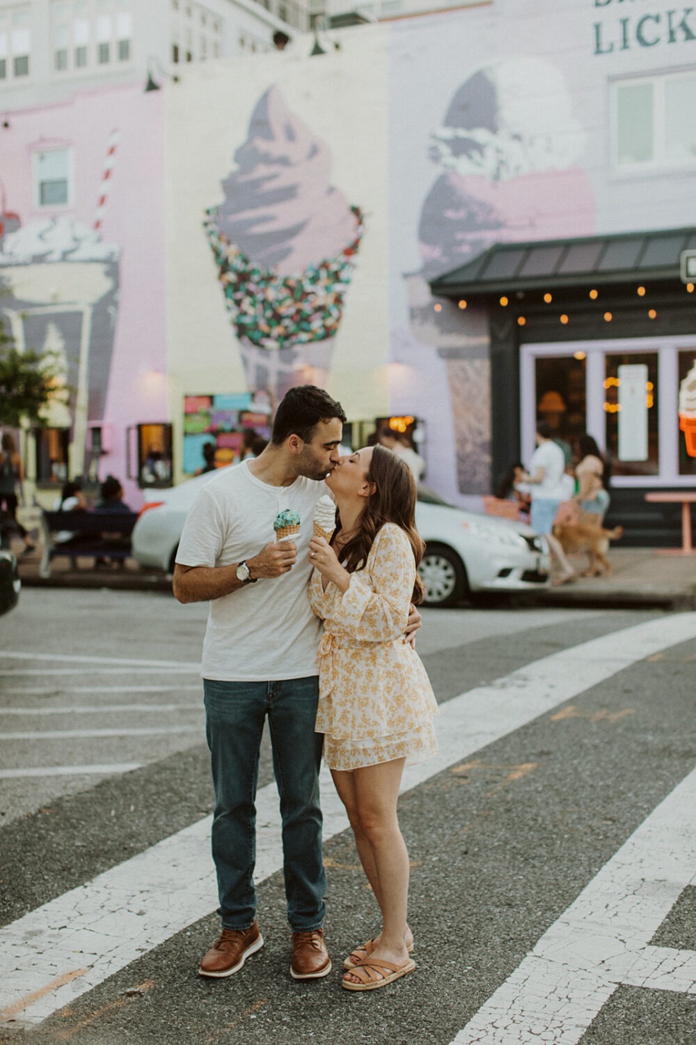 couple kisses holding ice cream cones at Baltimore engagement session