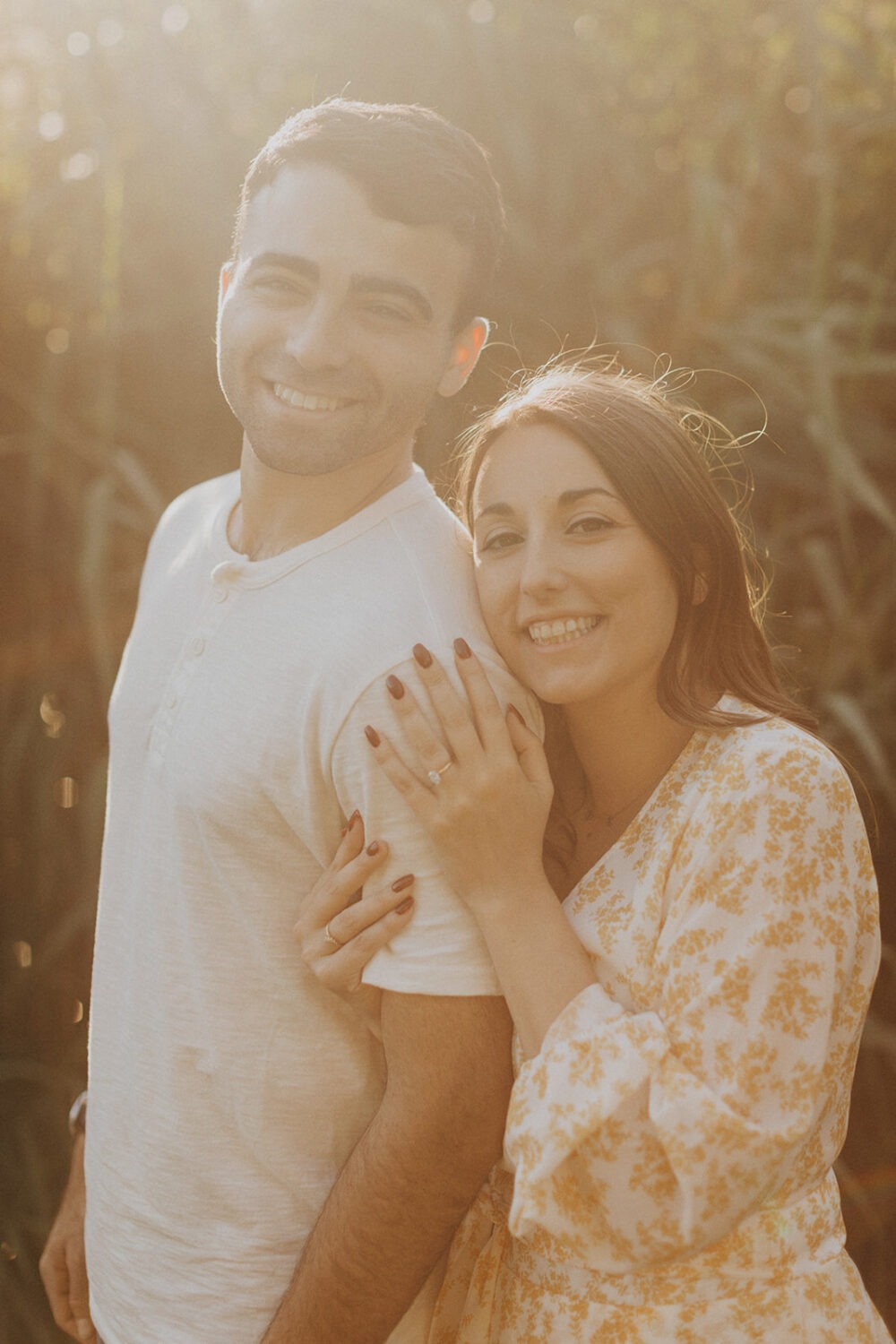couple embraces during at sunset summer engagement photos