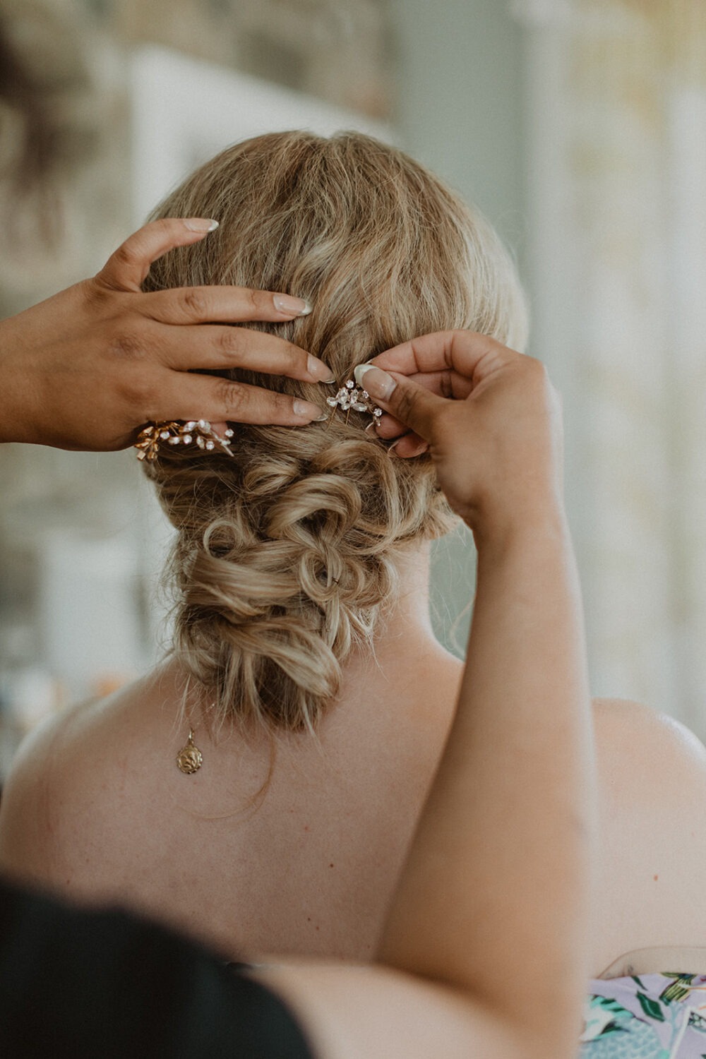 bride gets hair done on wedding day