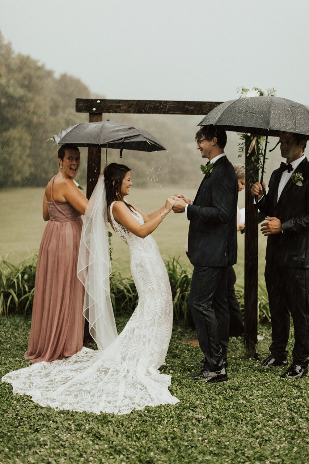 couple laughs during outdoor raining wedding ceremony