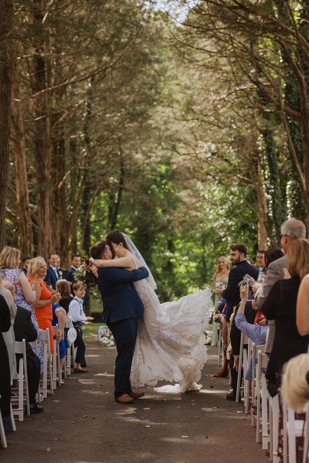 couple kisses in aisle as wedding photo poses
