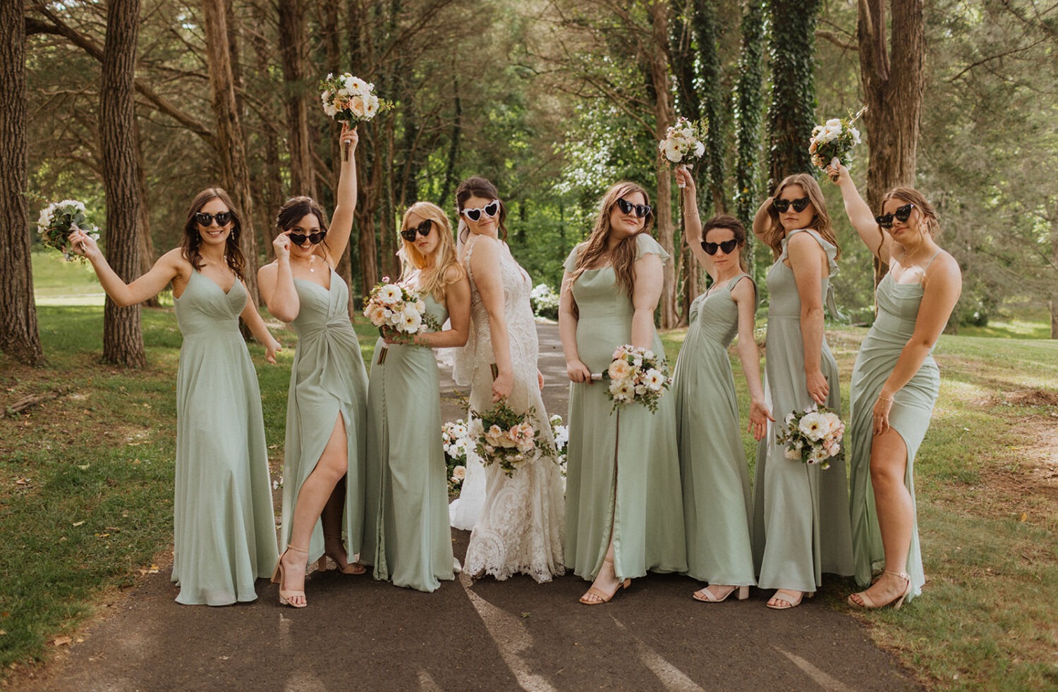 bride poses with bridesmaids wearing sunglasses doing wedding photo poses