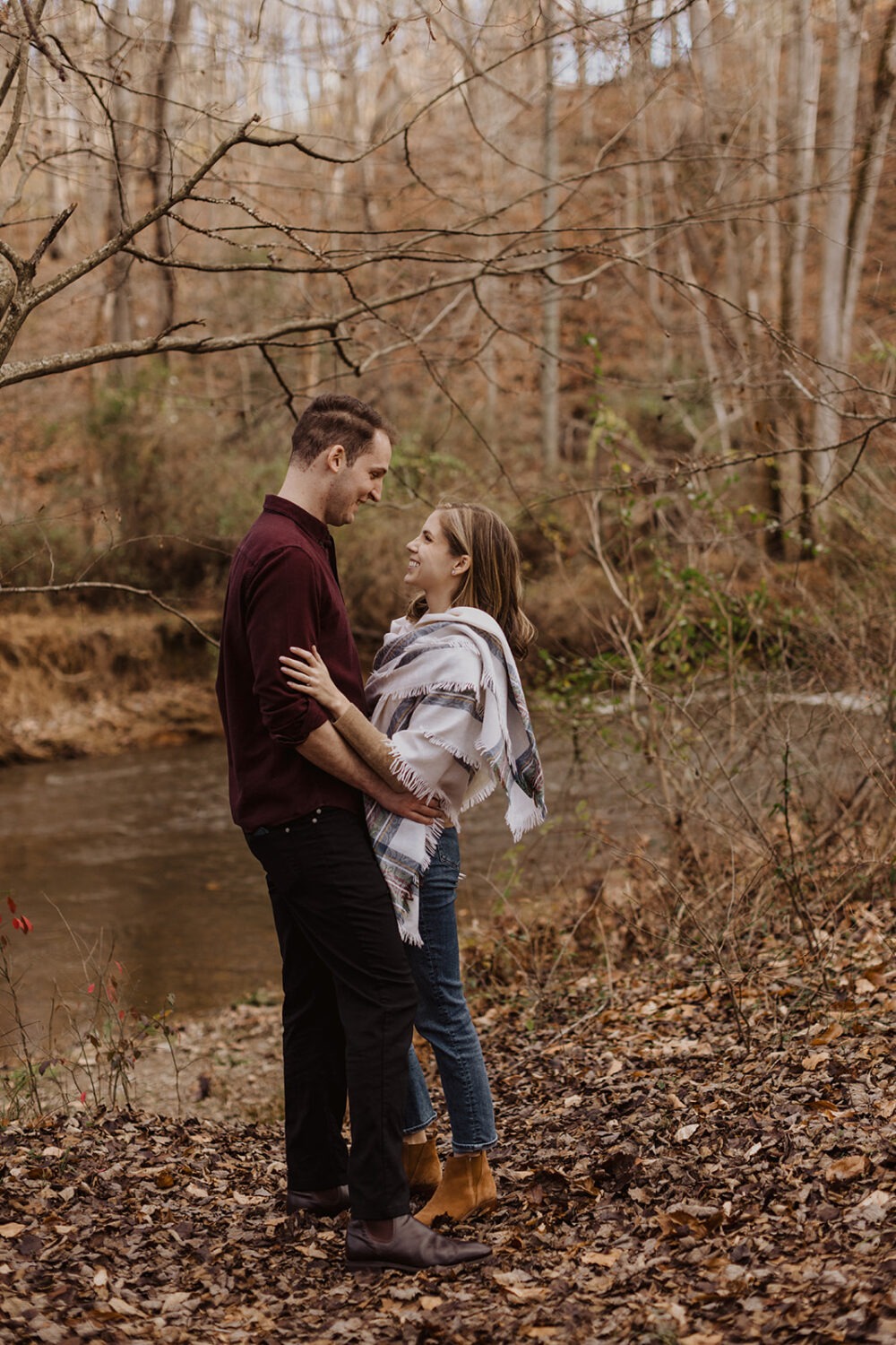 couple embraces each other at fall outdoor engagement session