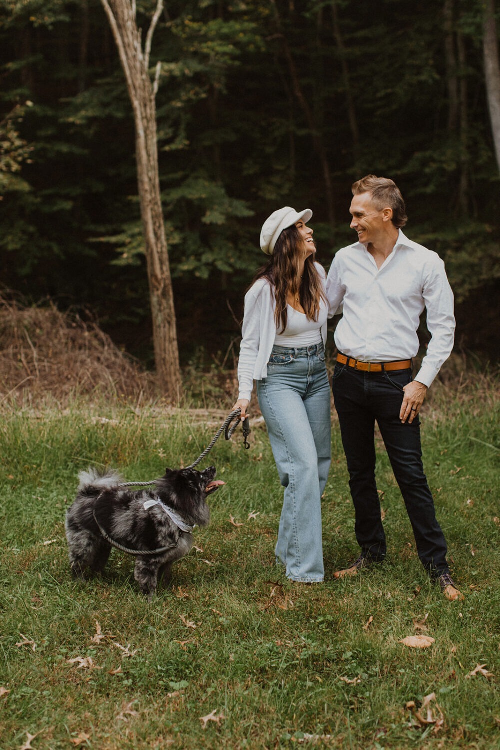 couple walks dog at outdoor engagement session