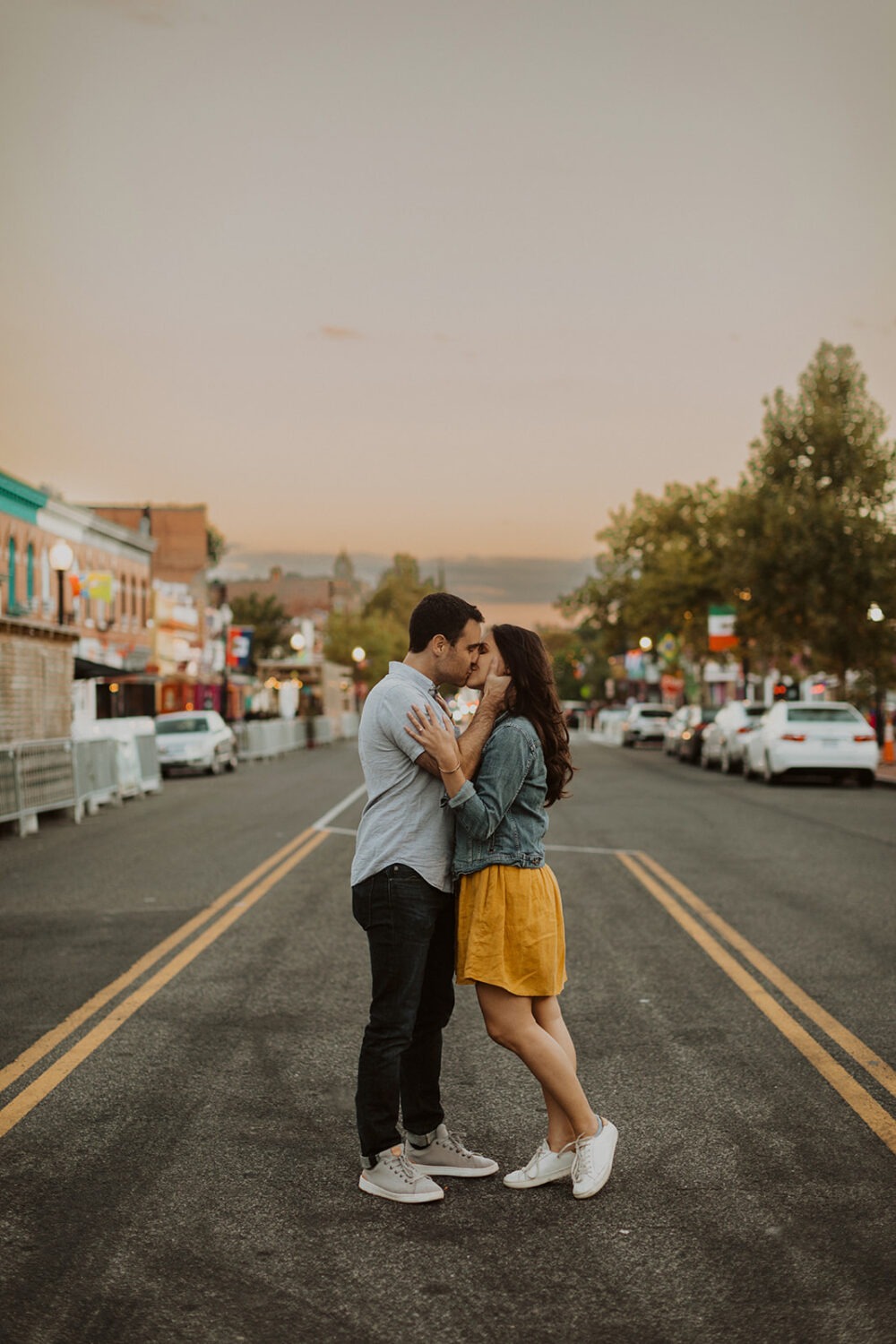 couple kisses wearing coordinating engagement shoot outfits