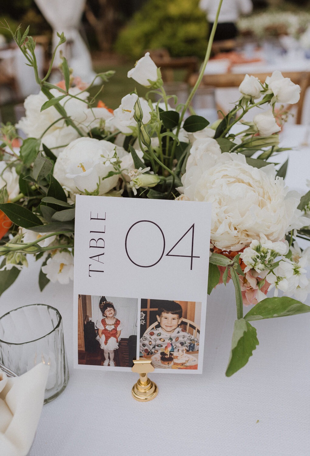 white florals and table numbers with photos at DIY wedding
