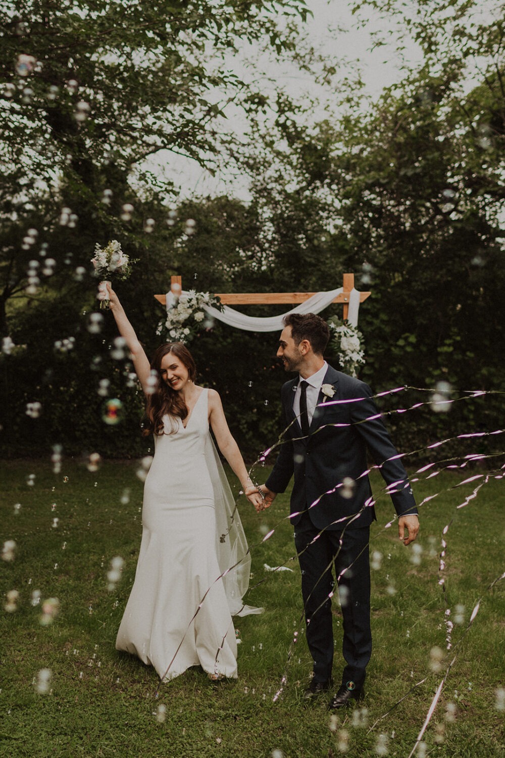 couple exits backyard wedding through bubbles