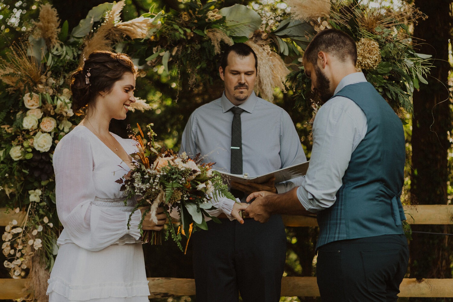 couple exchanges rings at backyard wedding