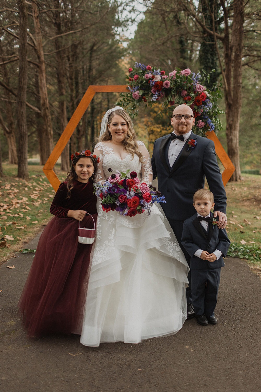 couple poses with flower girl and ring bearer at outdoor fall Poplar Springs wedding