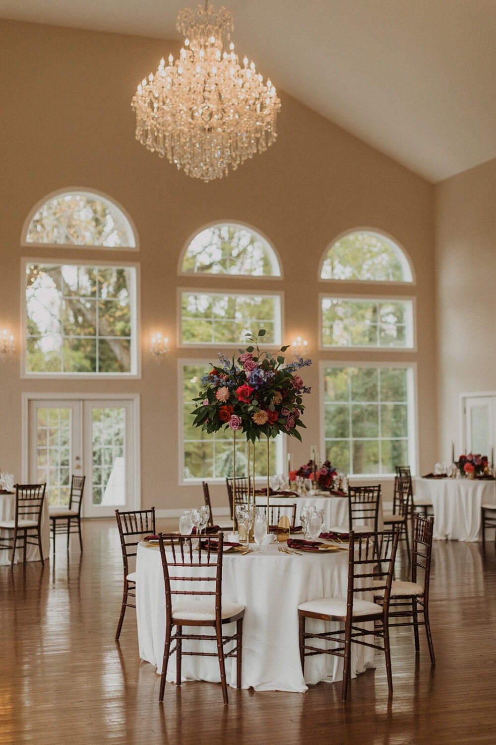 floral decor and chandelier at ballroom wedding reception