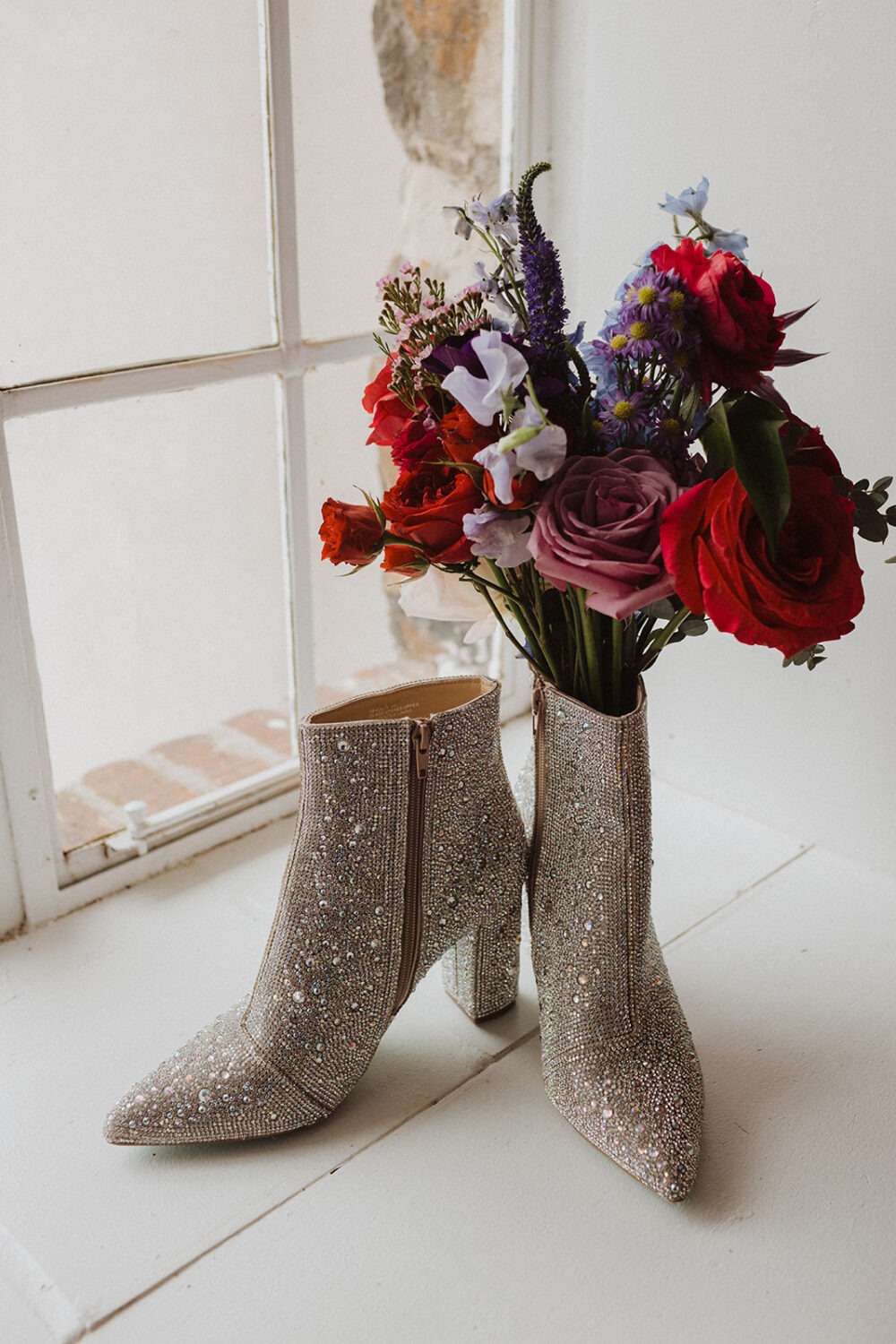 bride styles bedazzled shoes with bouquet using best wedding planning tips