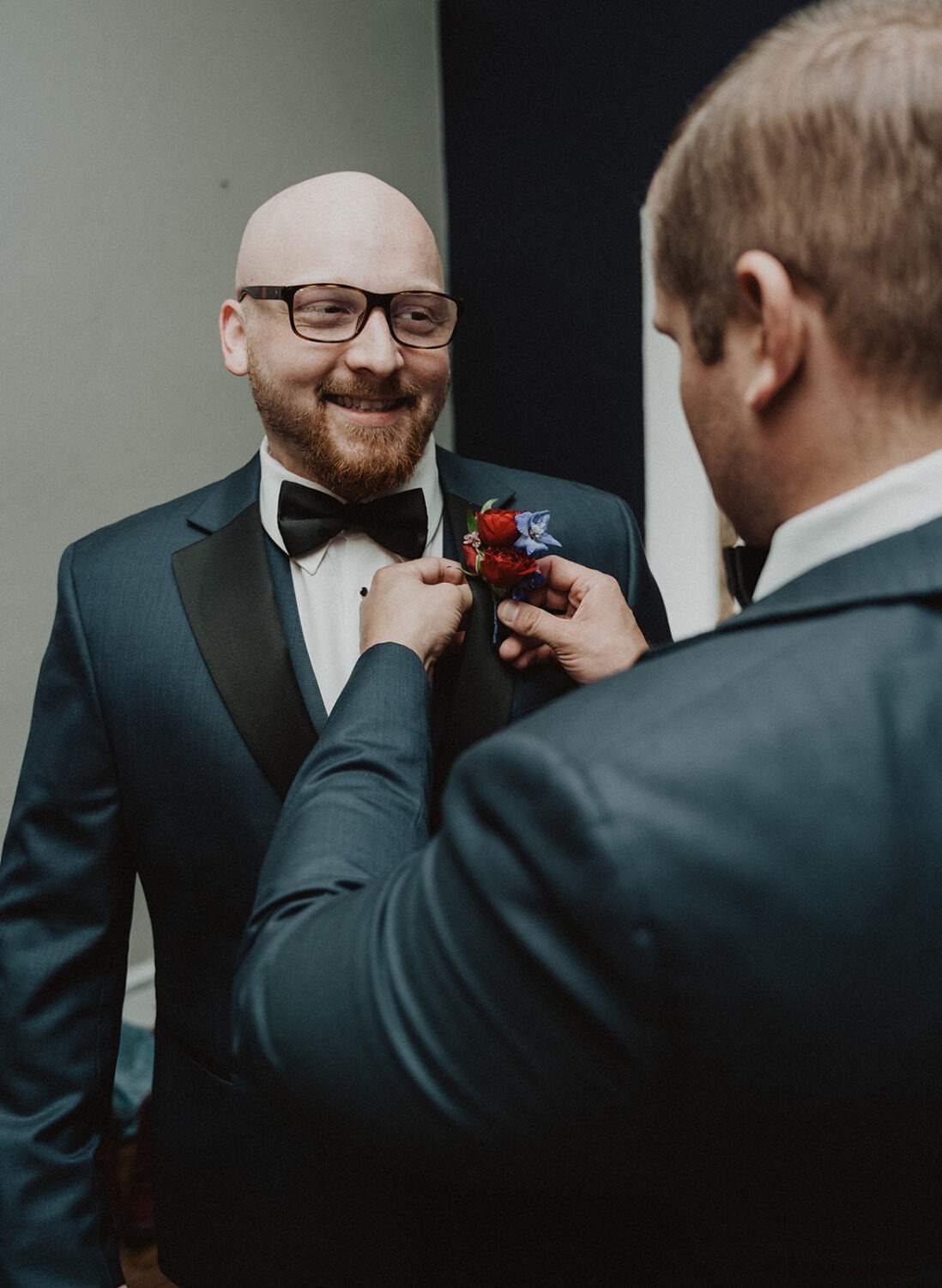 groom gets help with boutonniere using wedding planning tips