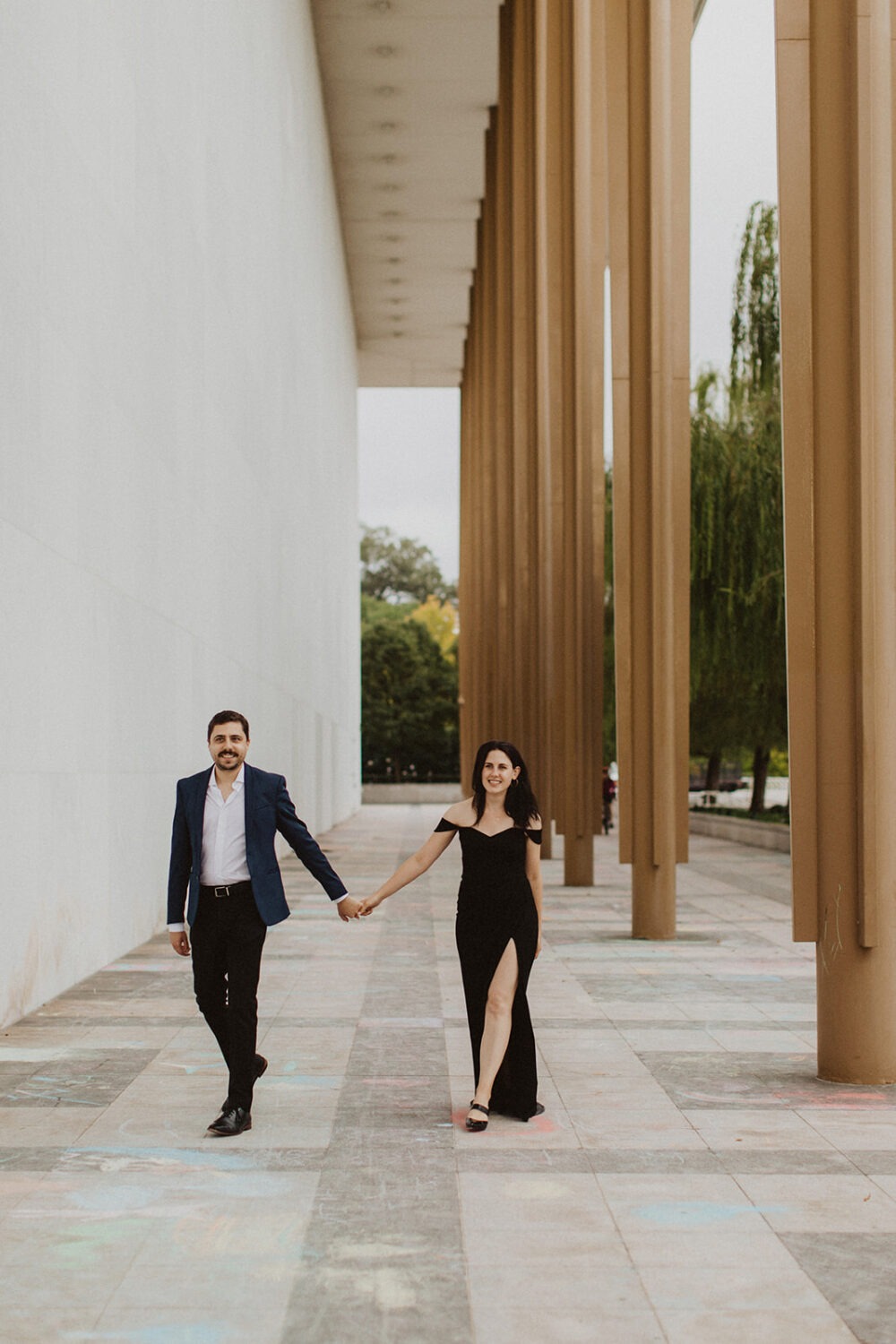 couple walks holding hands at Kennedy Center engagement session