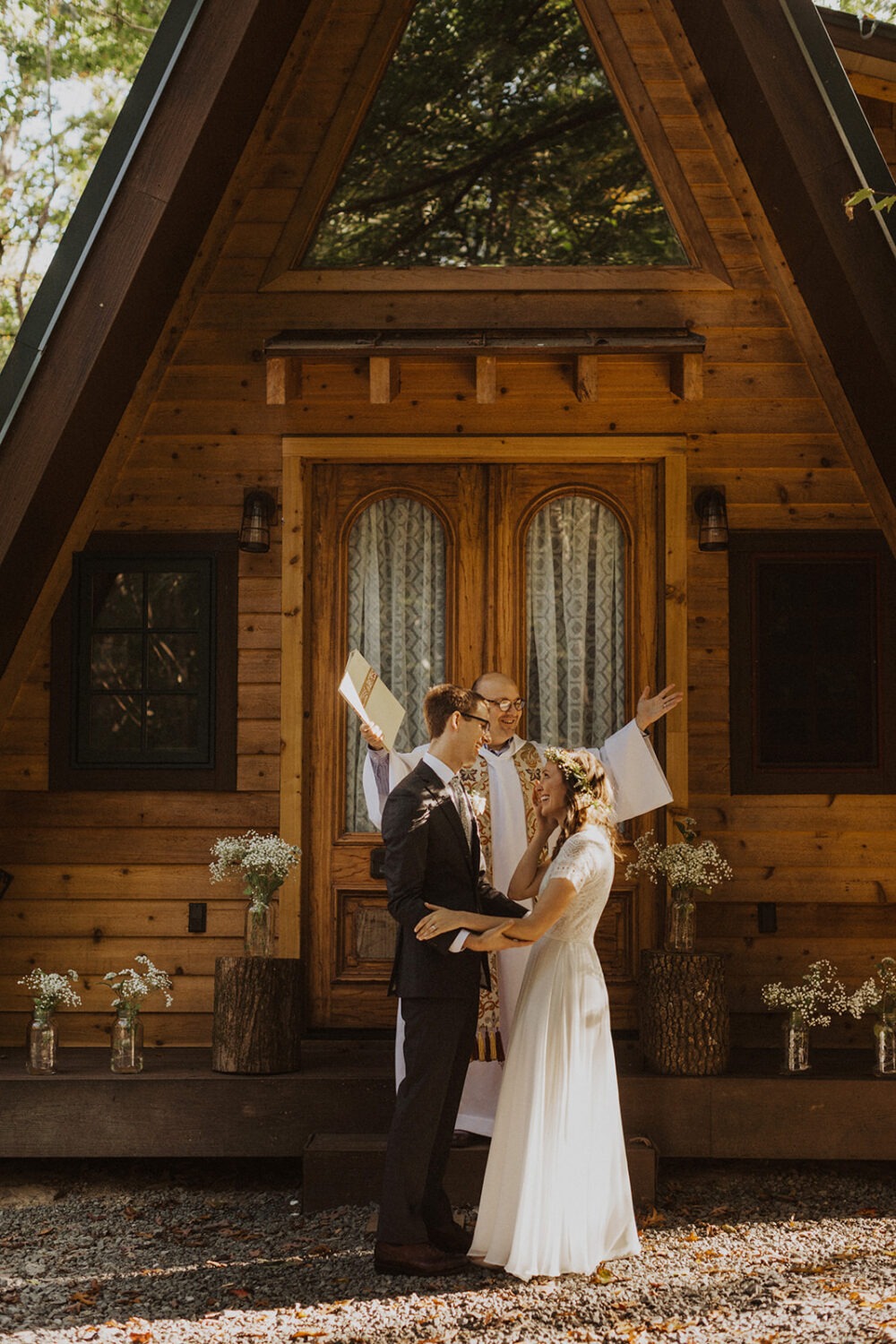 couple exchanges vows in front of a-frame cabin wedding venue