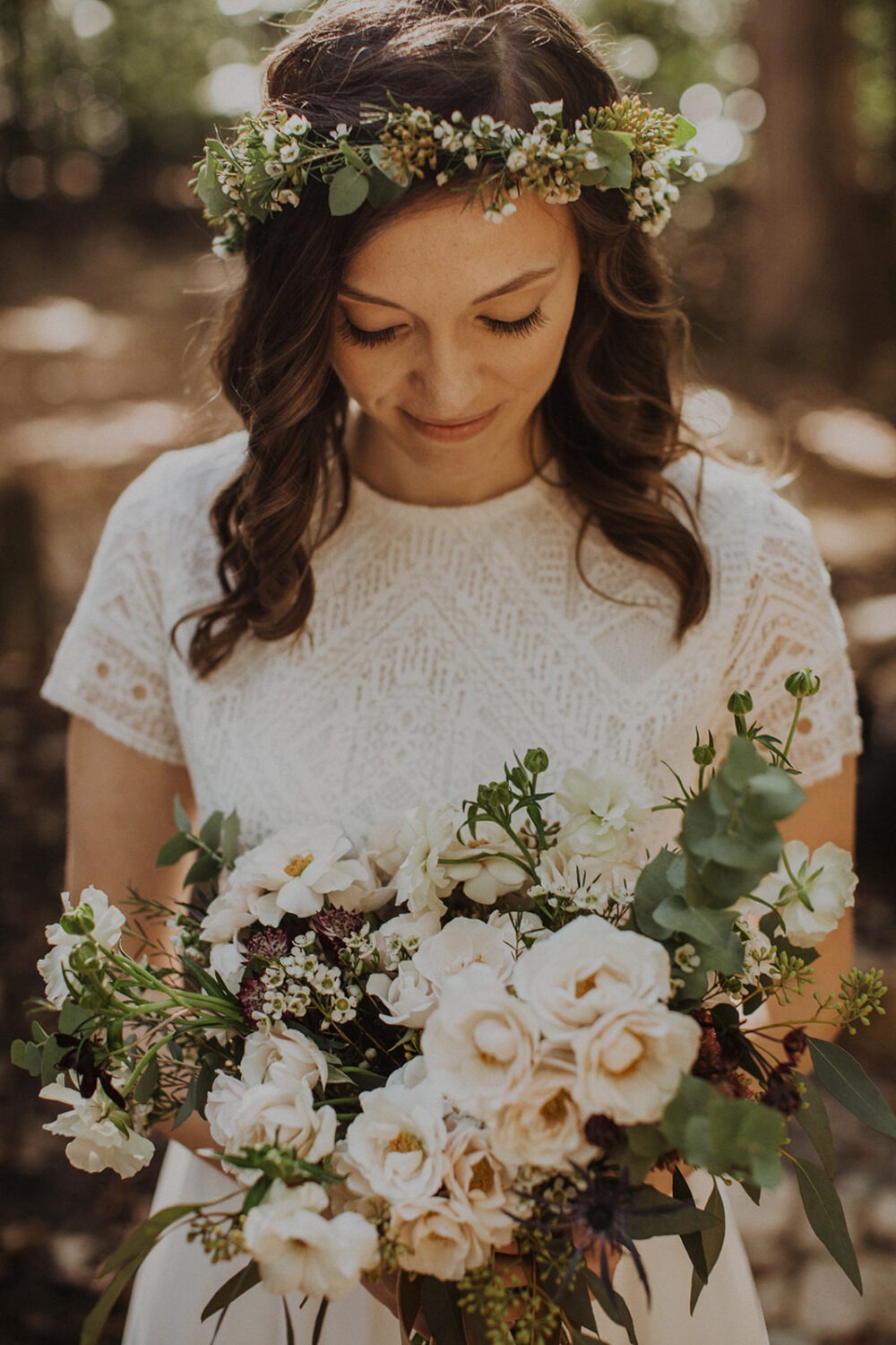 bride holds white wedding florals at woods elopement