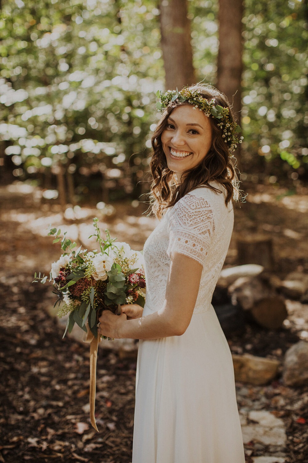 bride holds white wedding florals at woods elopement