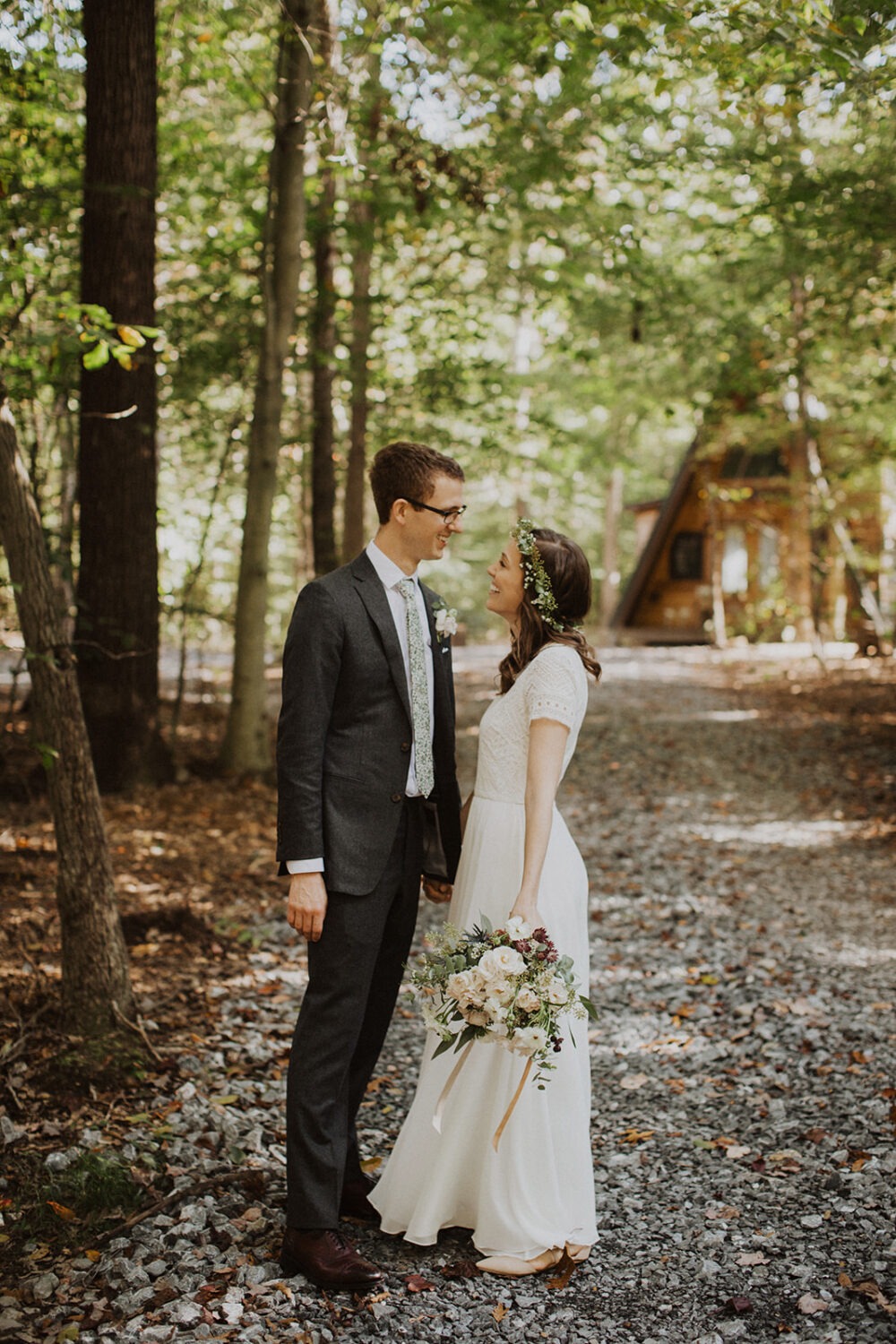 couple walks down lane in front of a-frame cabin wedding venue