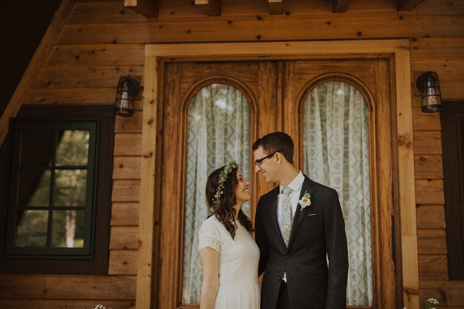 couple embraces in front of a-frame cabin wedding venue