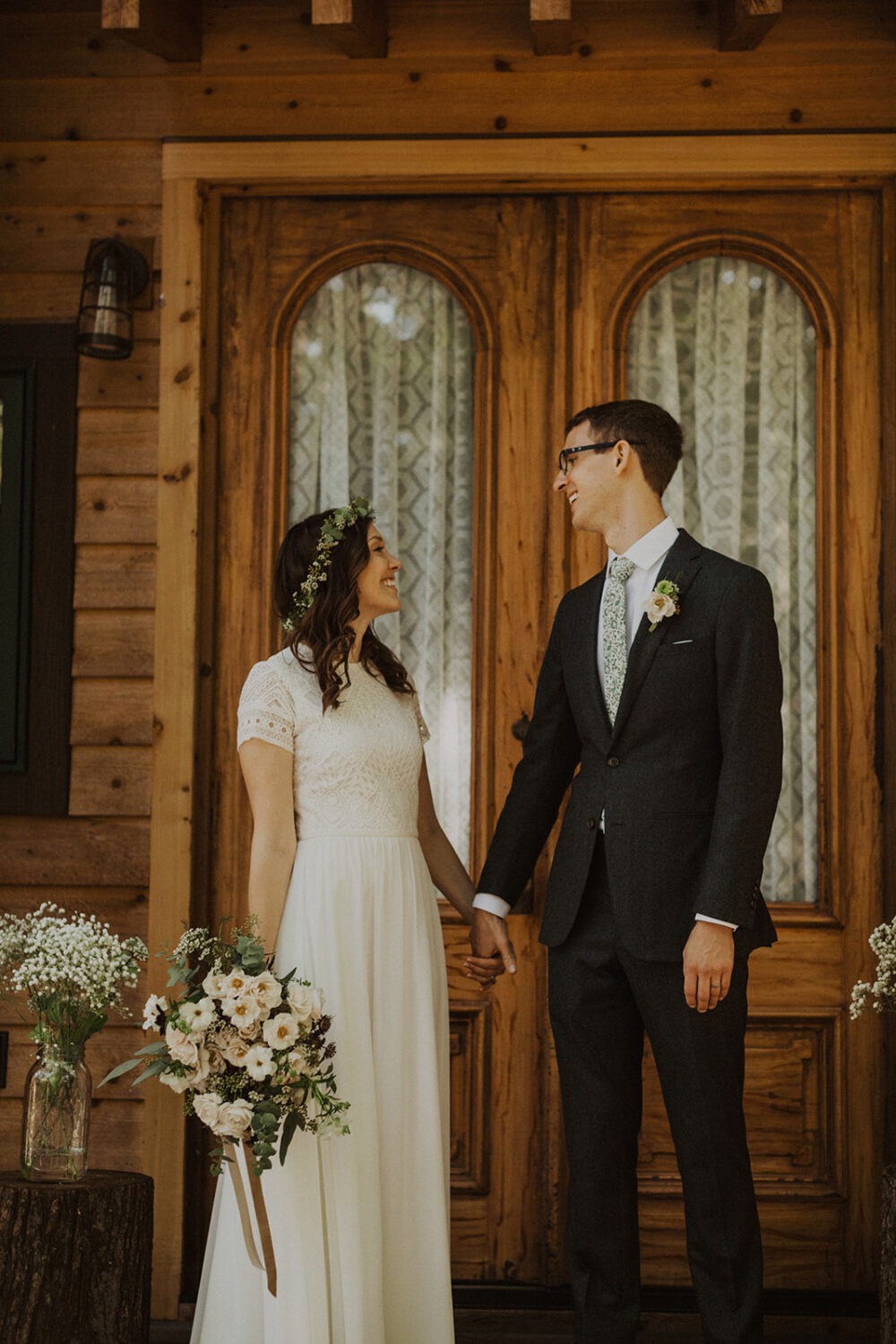 couple holds hands in front of a-frame cabin wedding venue