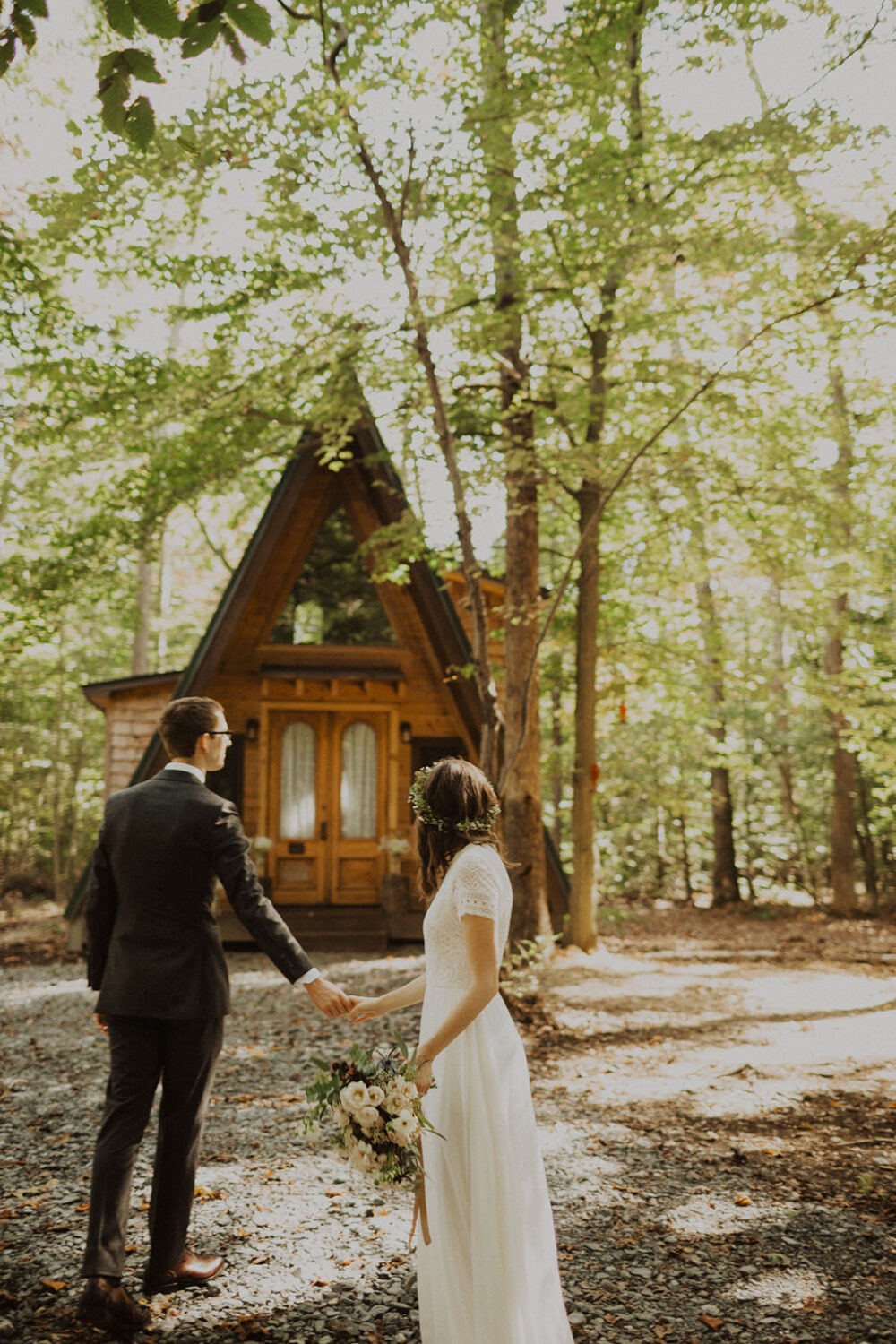 couple walks in front of a-frame cabin wedding venue
