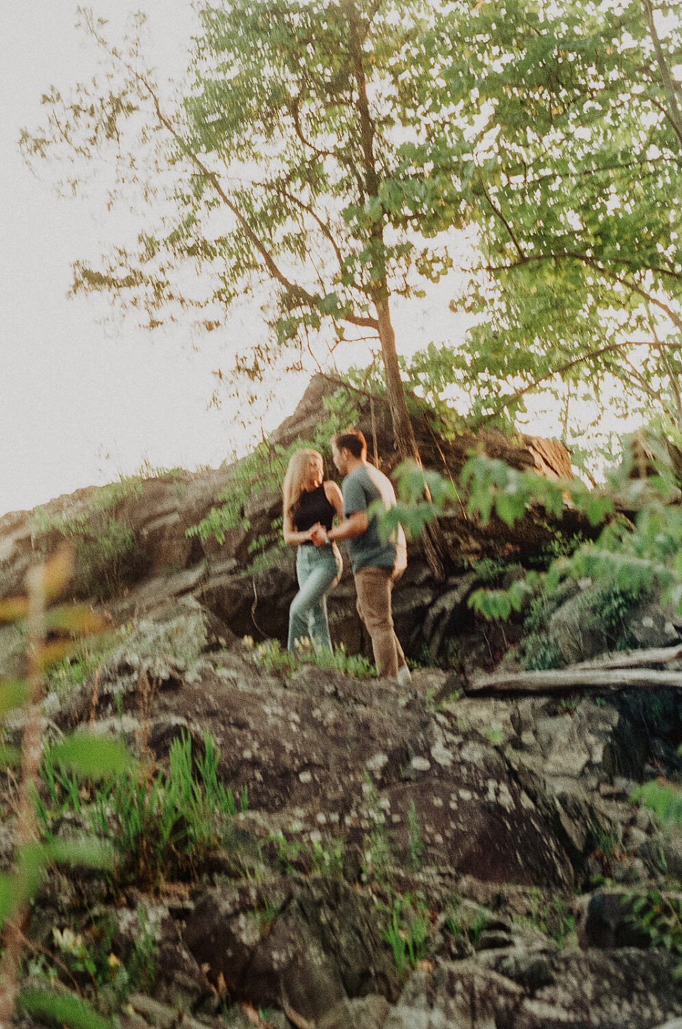 couple walks through woods at engagement session
