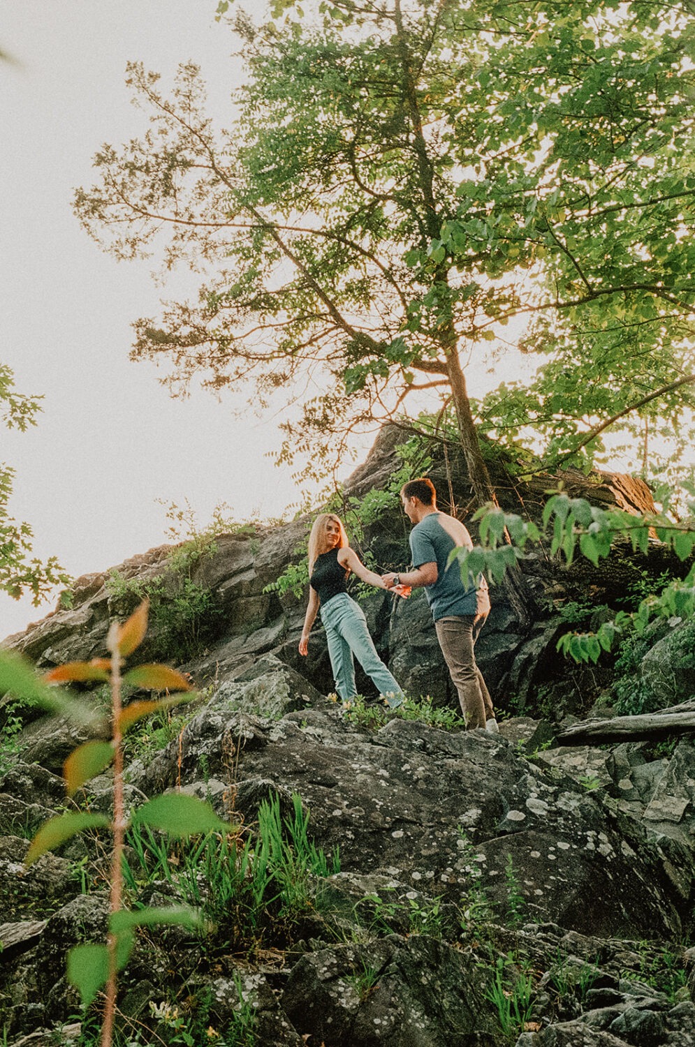 couple walks through woods at engagement session
