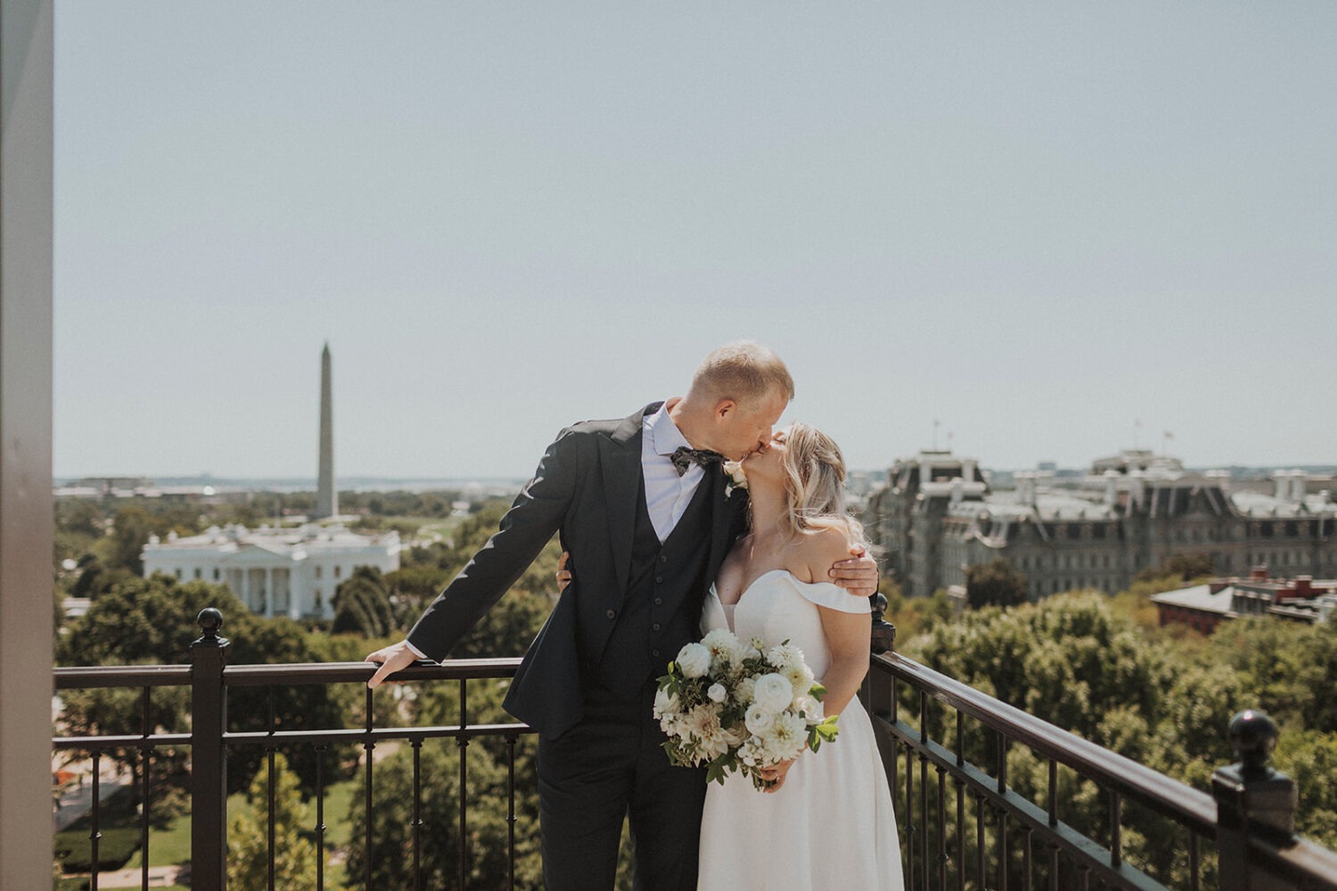 couple kisses at Washington DC rooftop intimate wedding
