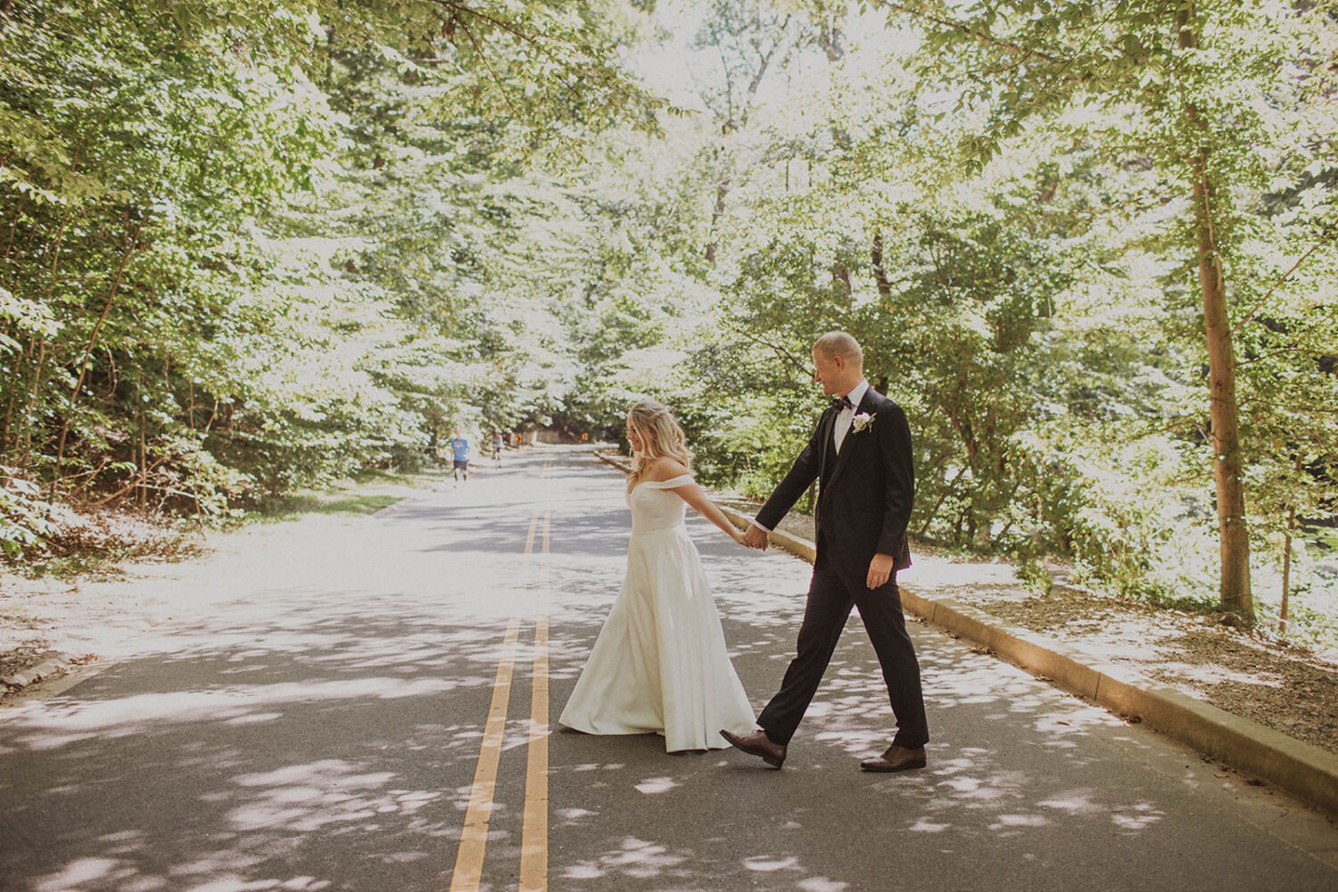 couple walks through forest at Rock Creek Park elopement