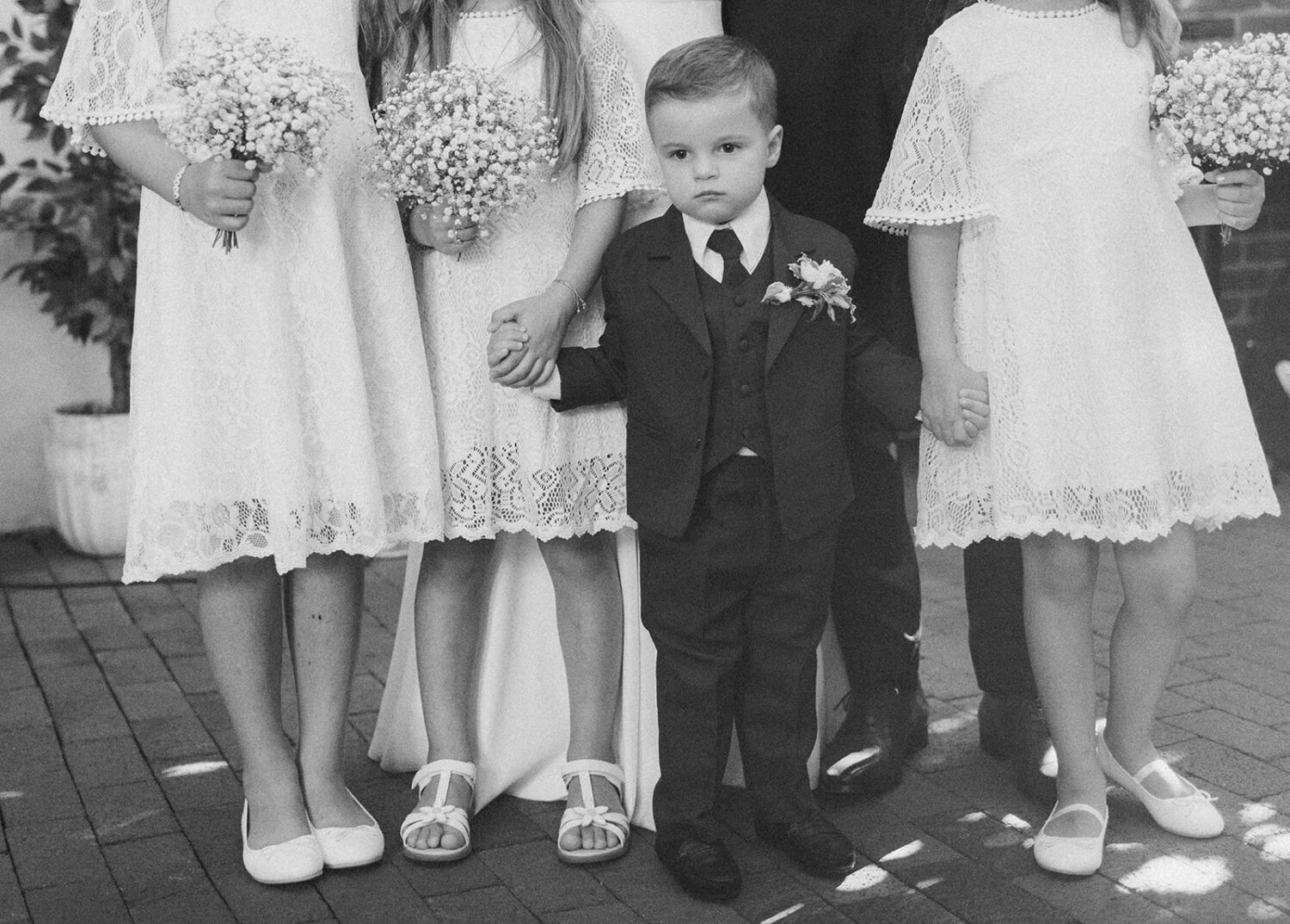 ring bearer holds hands with flower girls at intimate wedding