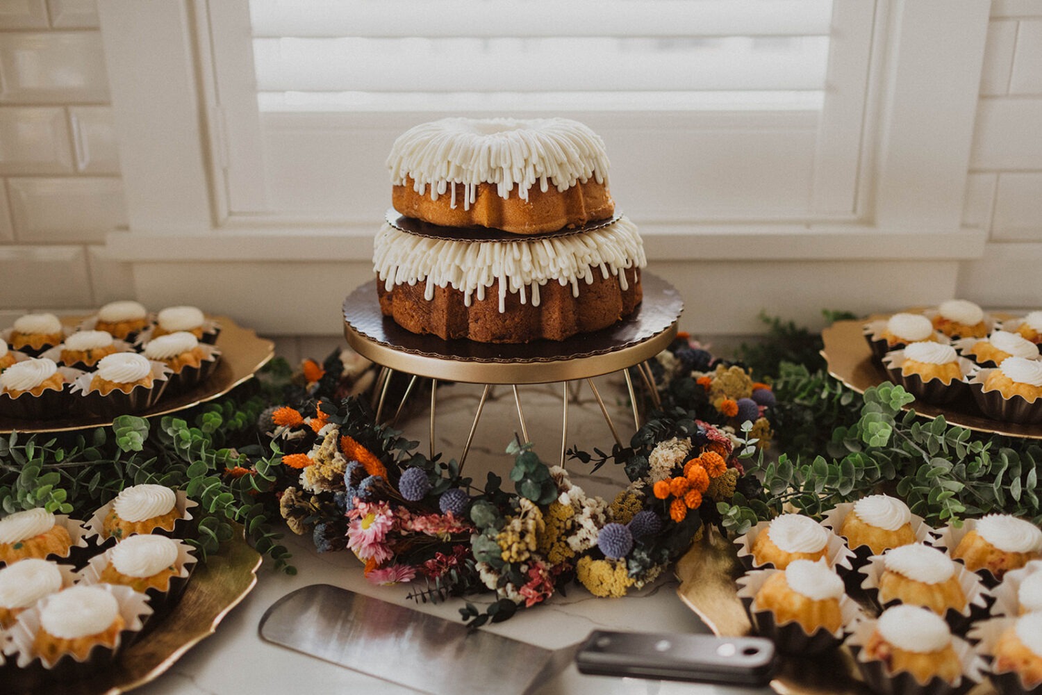 cakes and cupcakes with wildflowers at wedding reception