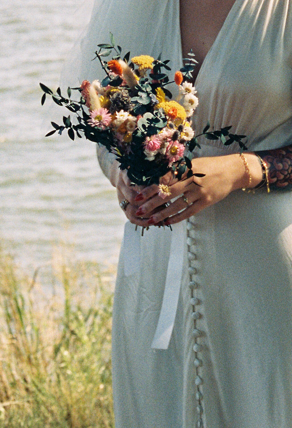 bride holds dried wedding flowers captured by film wedding photography