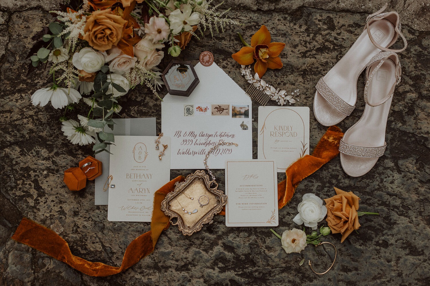 wedding invitation and accessories flat lay with fall wedding florals