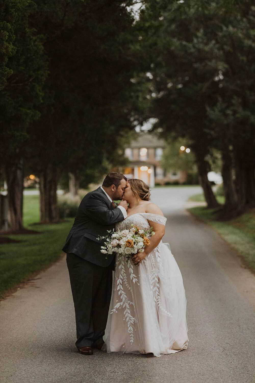 couple kisses under tree at Walker's Overlook farm wedding venue
