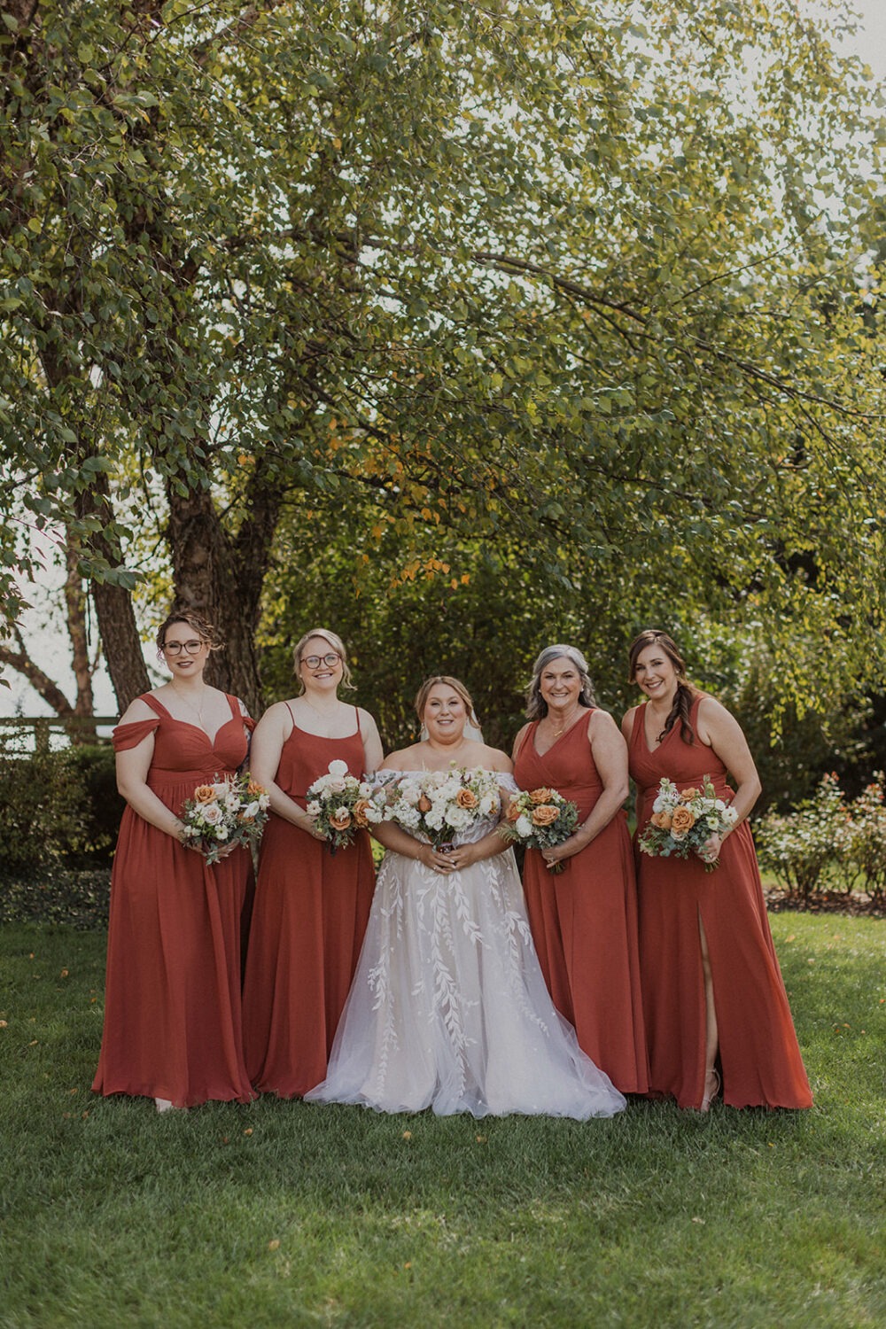 bride stands holding bouquet with bridesmaids at Walker's Overlook farm wedding venue