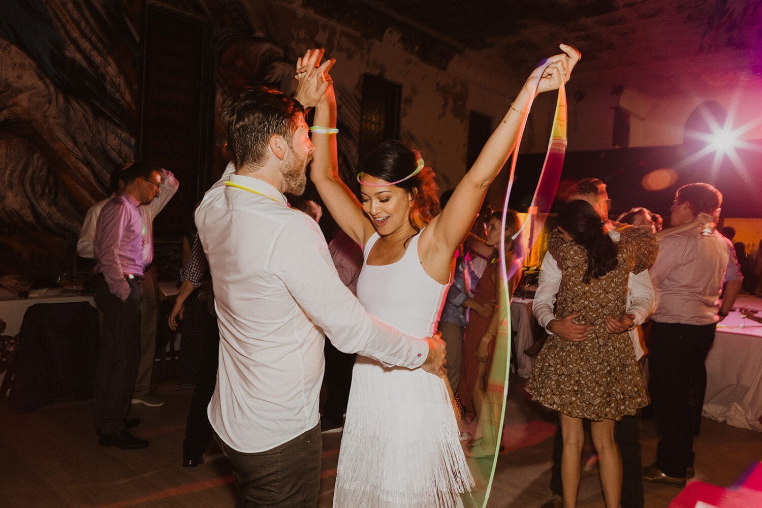 couple dances during wedding reception with glow sticks
