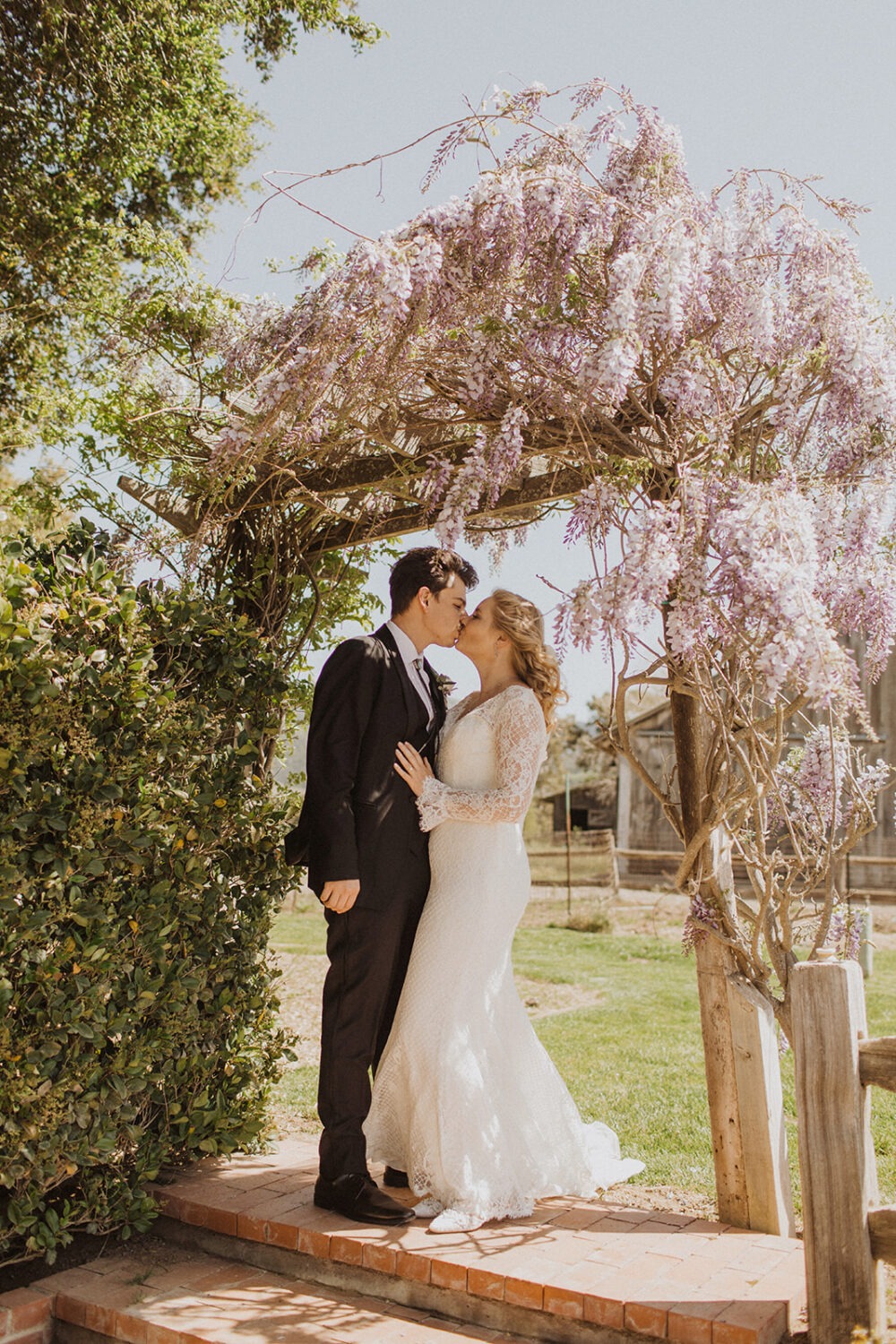 couple kisses under flowery tree