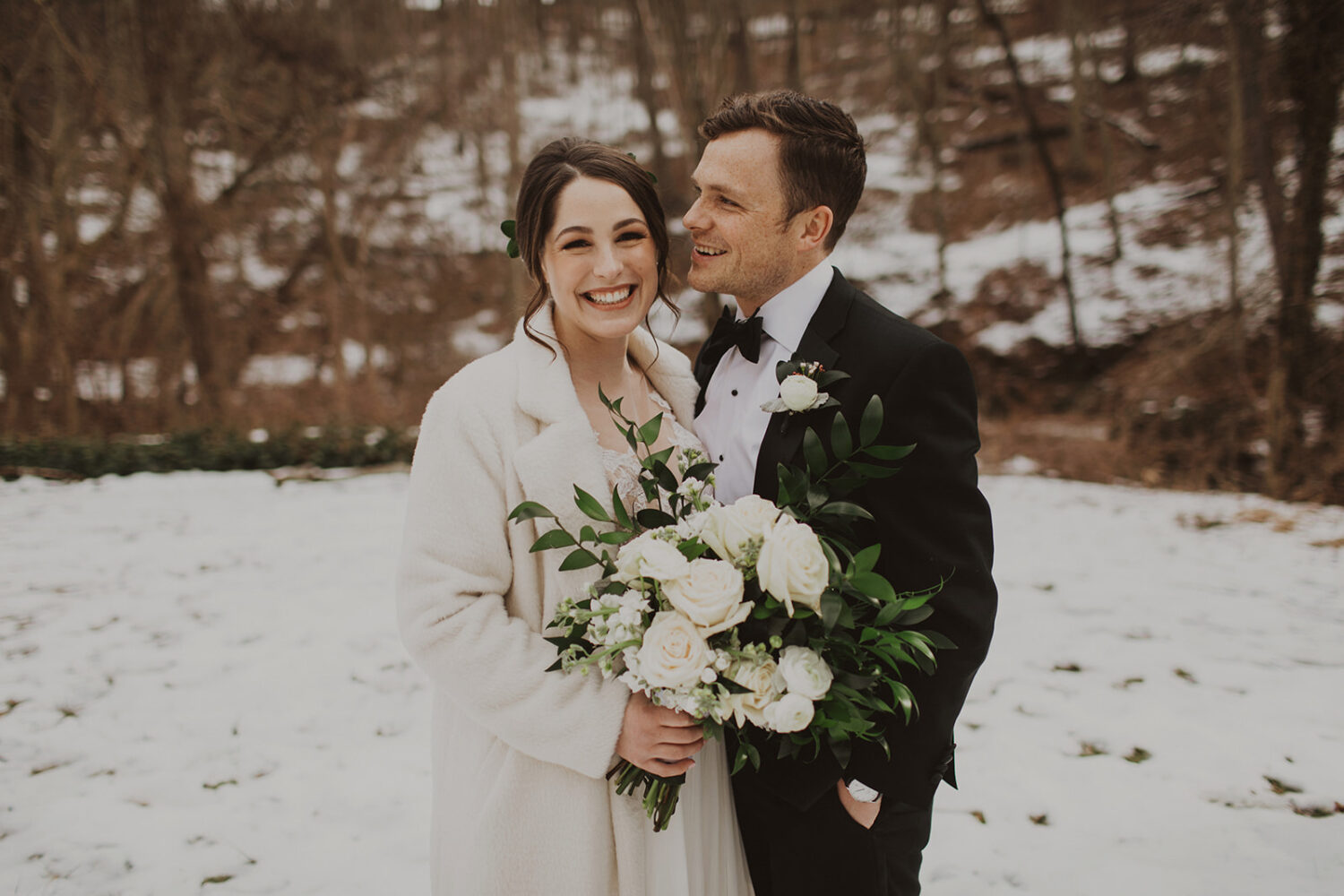 couple embraces at snow-covered elopement