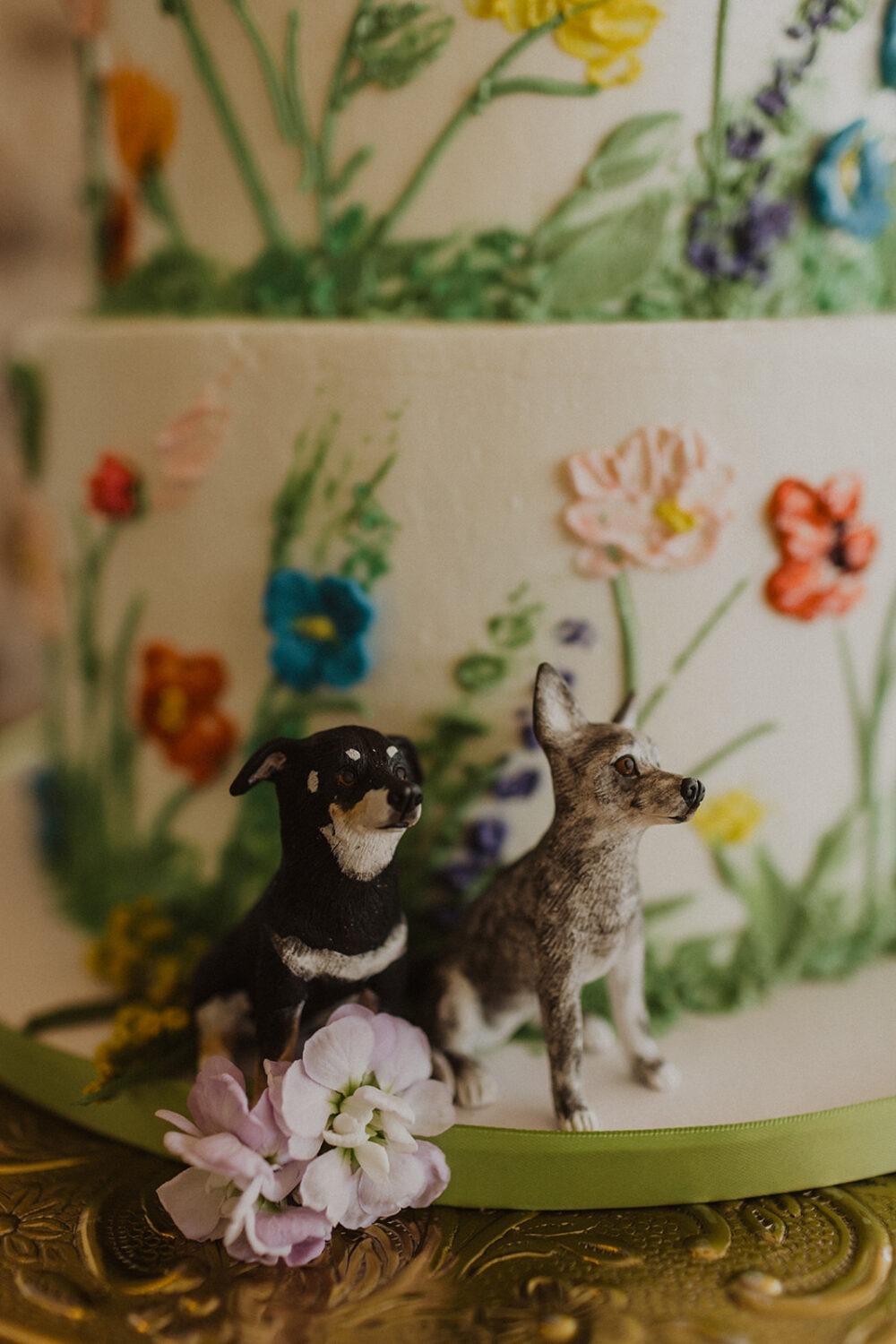 dog figurines decorate wedding cake as example of 2024 wedding trends