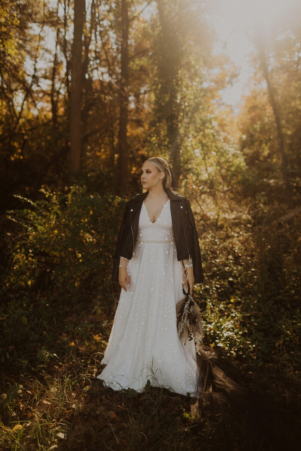 bride stands in sunset wearing leather jacket