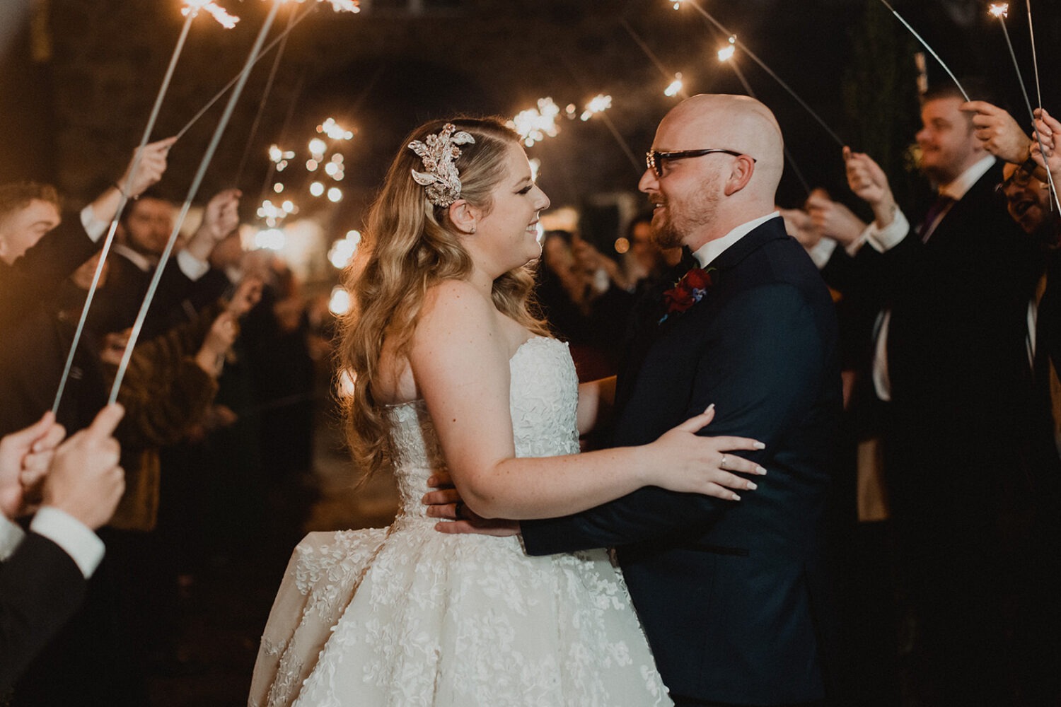 couple walks under sparklers as example of 2024 wedding trends