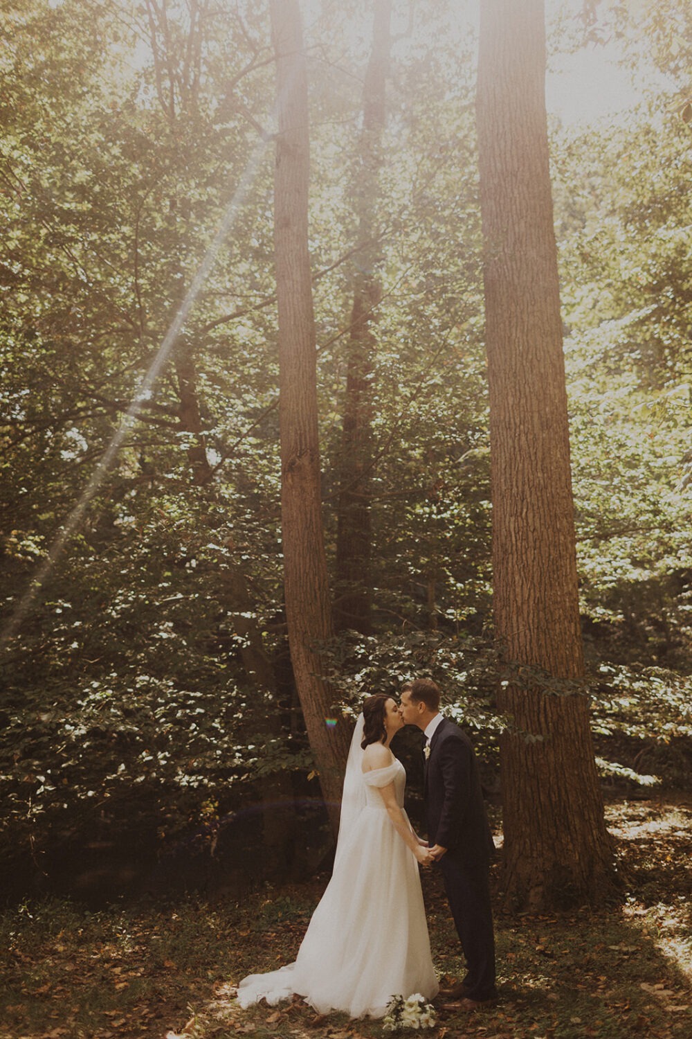 couple kisses at forest sunset elopement