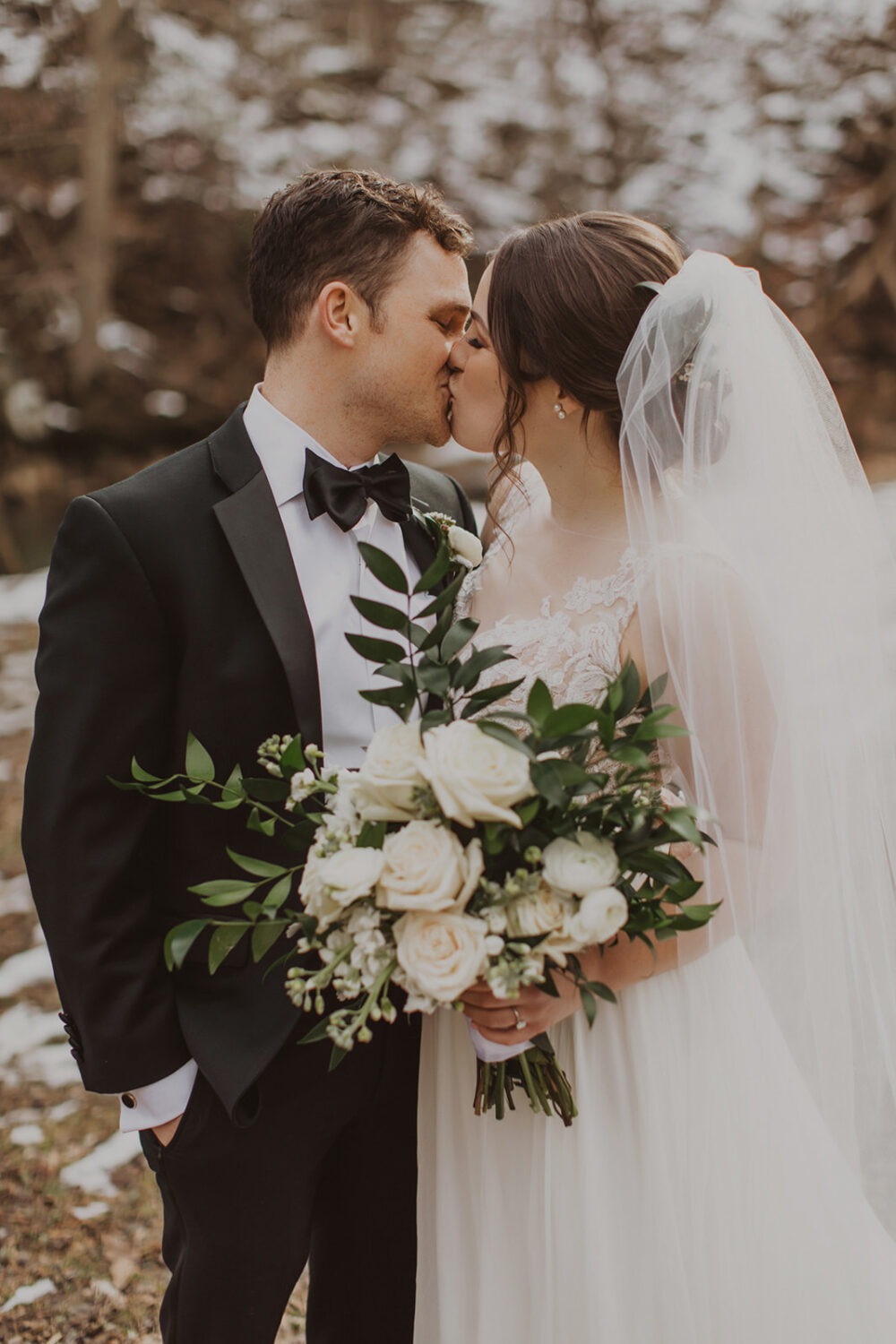 couple kisses at snowy outdoor elopement