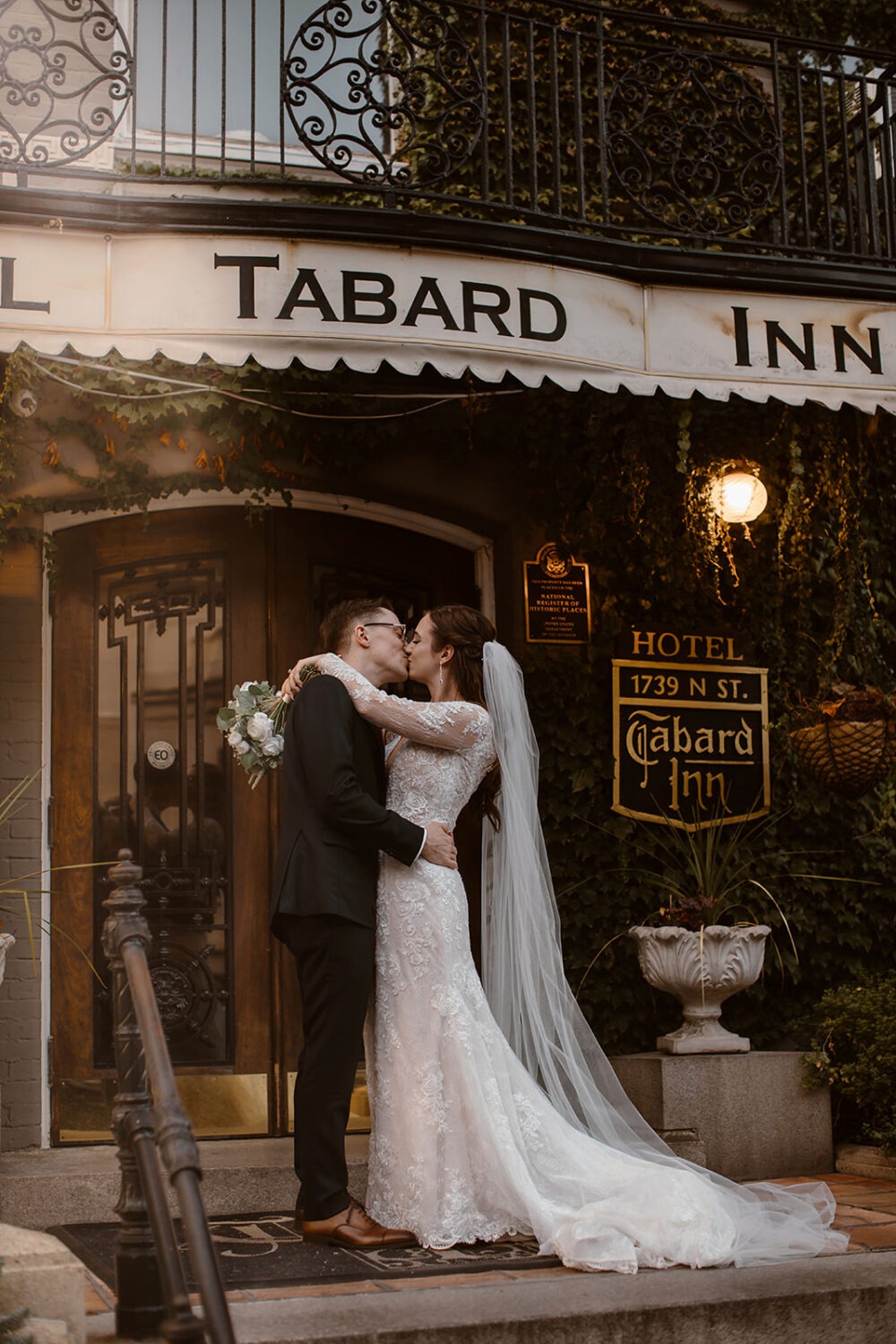 couple kisses in front of Tabard Inn wedding venue