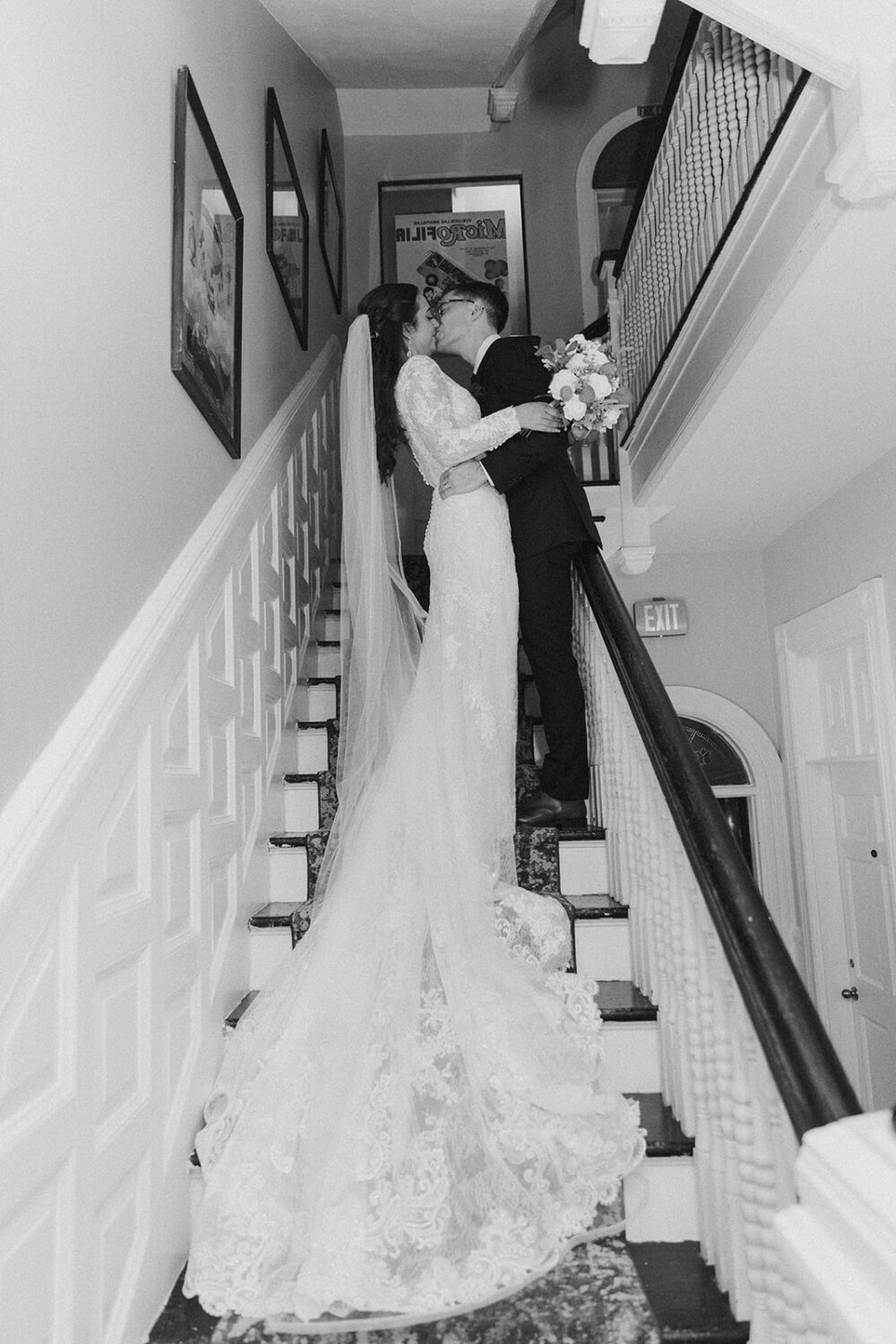 couple kisses on staircase at Tabard Inn wedding venue