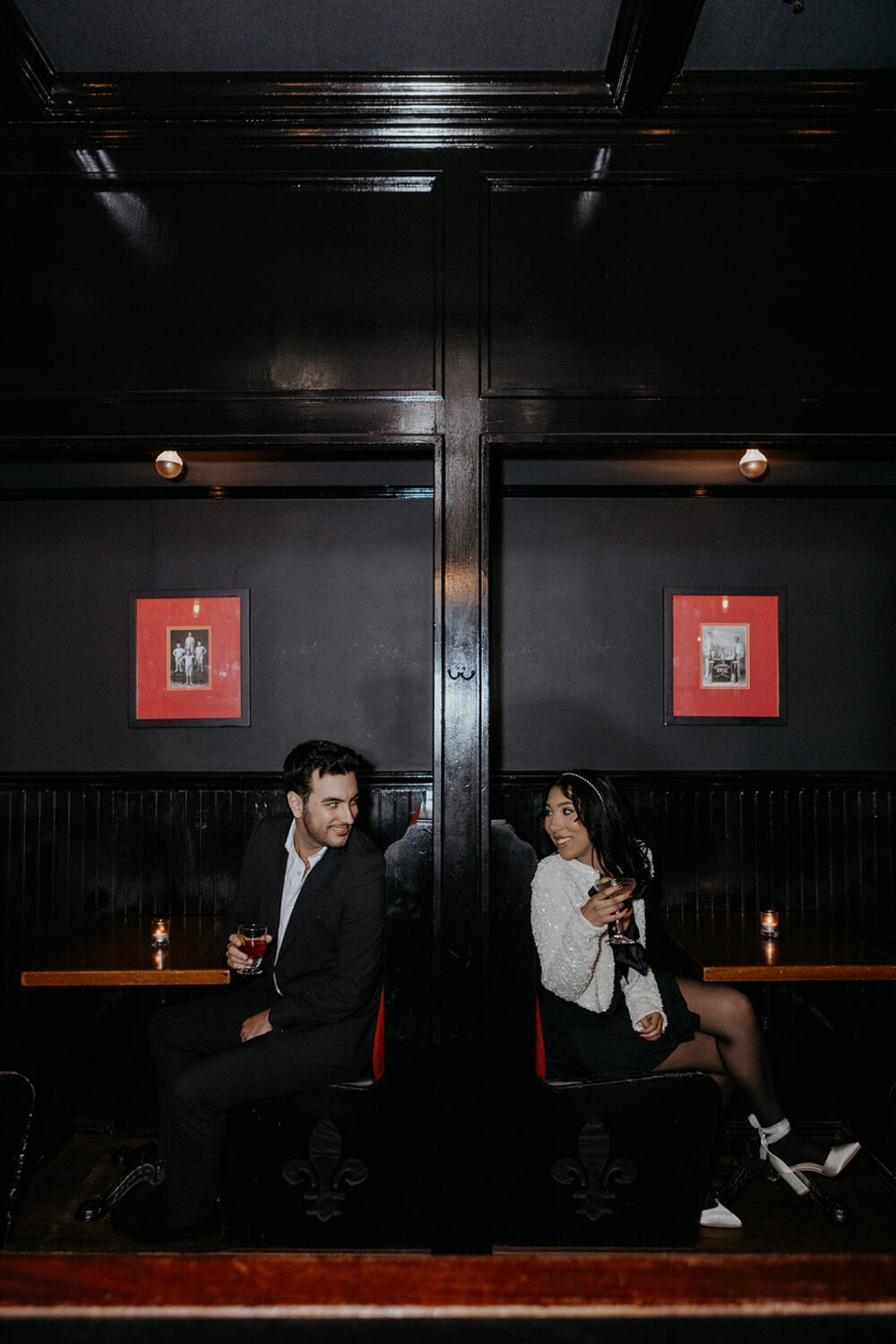 couple looks at each other from adjacent booths at cocktail bars in DC