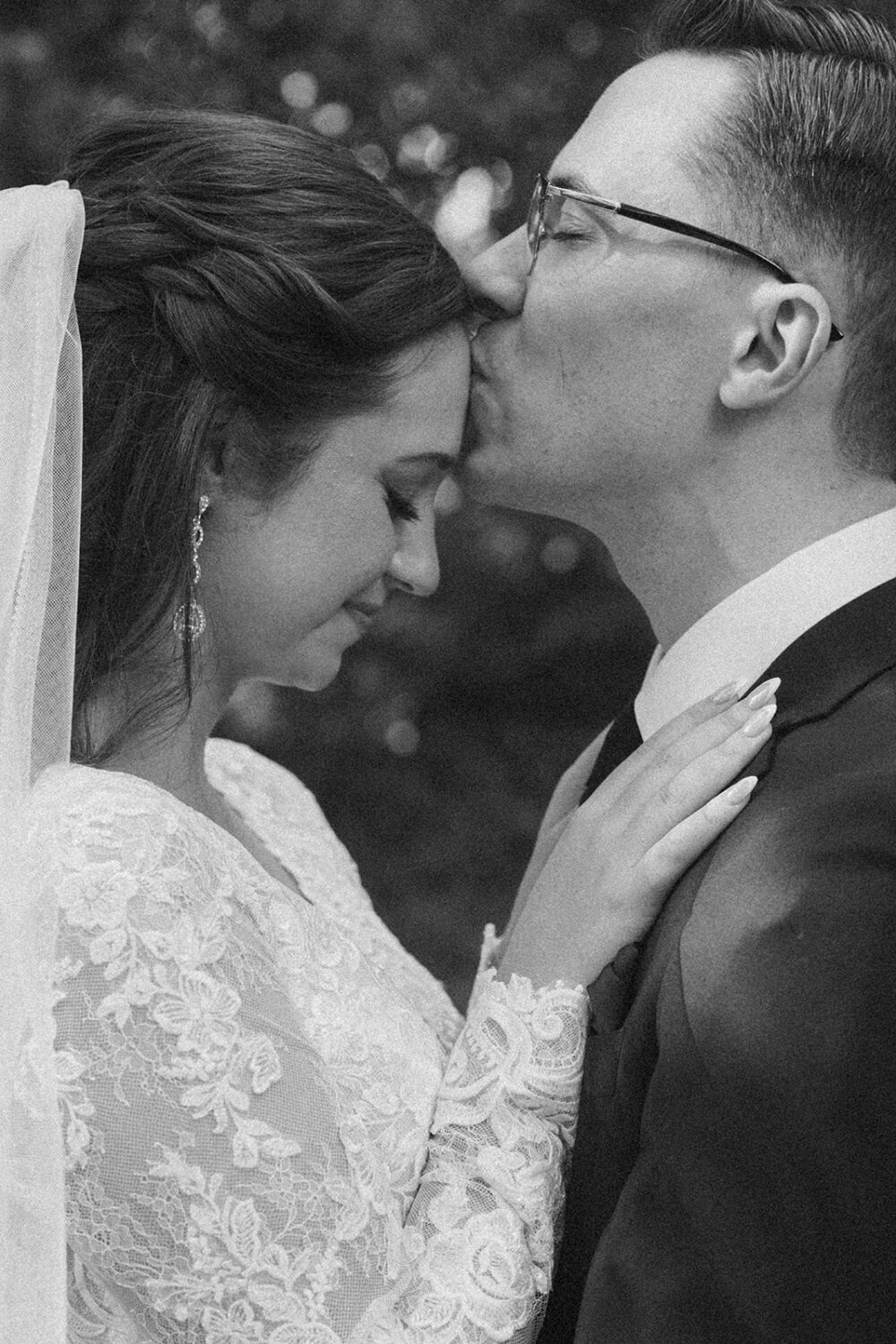 groom kisses bride's forehead