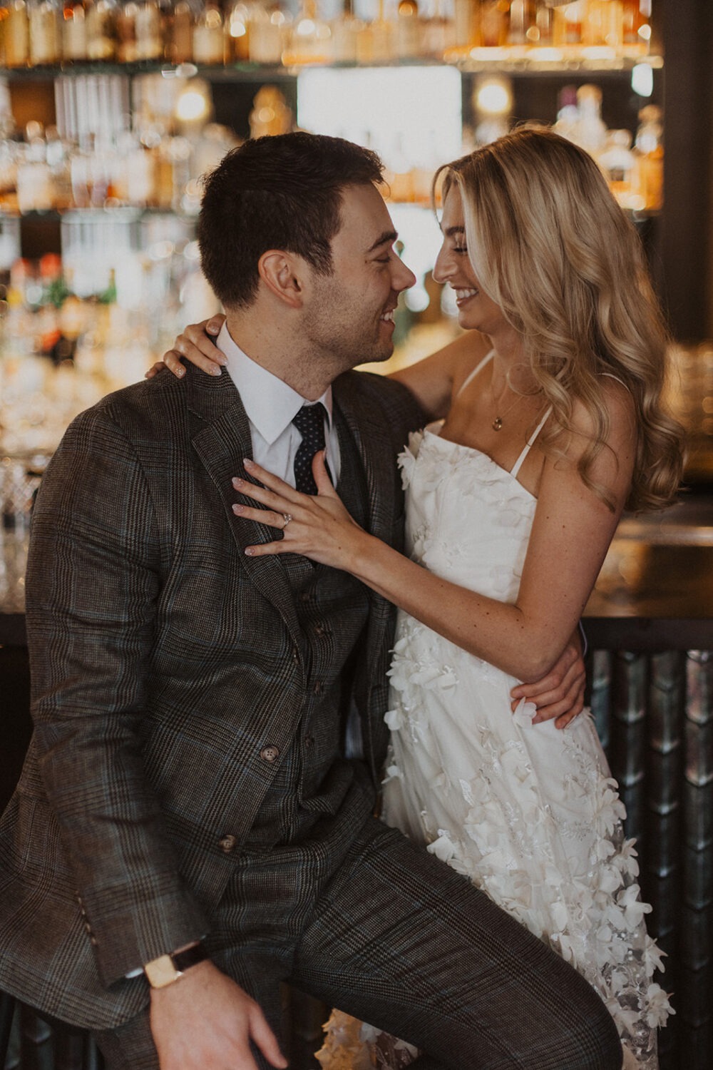 couple laughs embracing at bar engagement session 